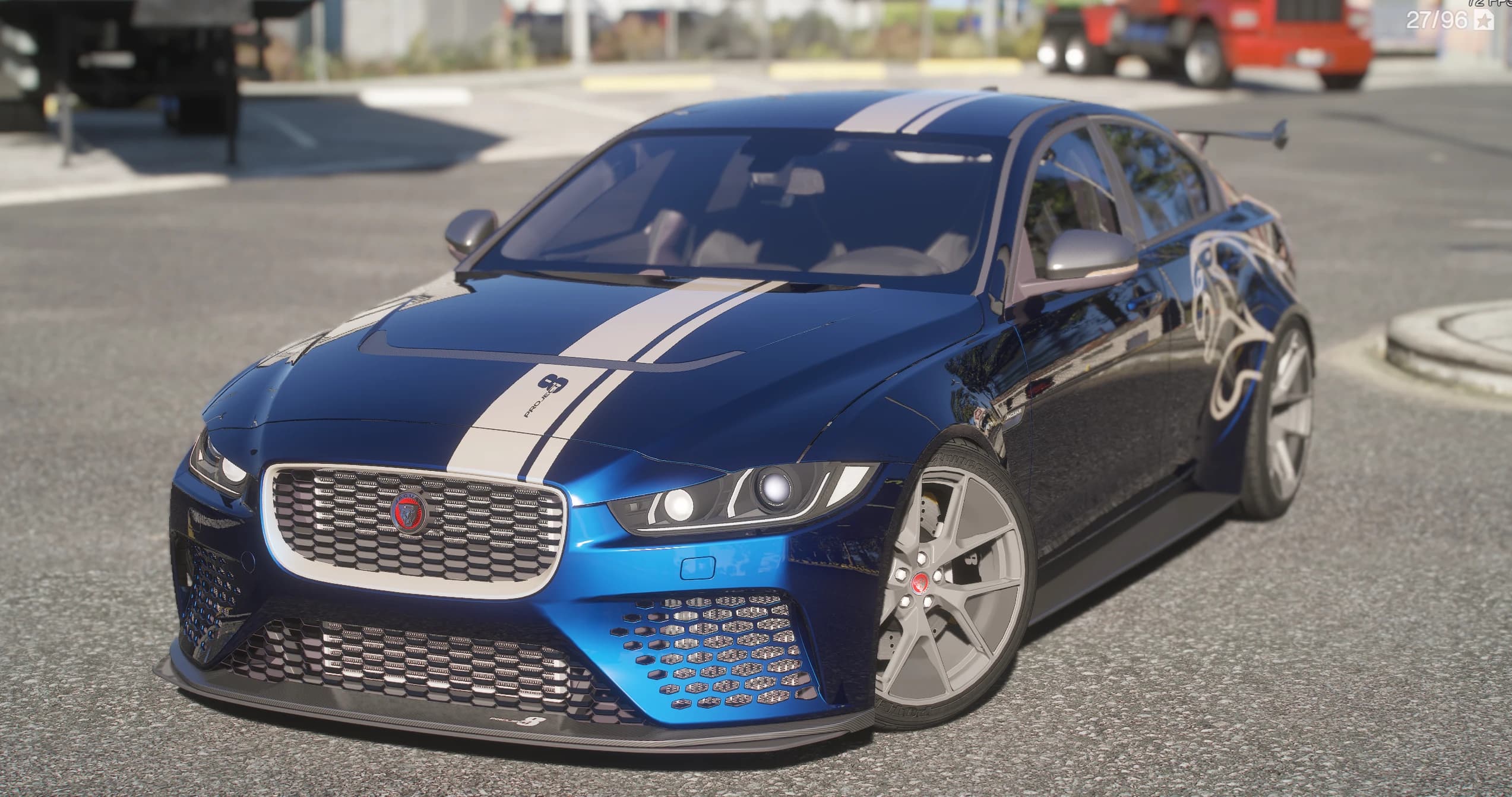2018 Jaguar XE SV Project 8 in metallic blue, front three-quarter in daylight, white stripe with a PROJECT 8 decal over the hood, deep mesh front bumper, carbon splitter and silver five-spoke wheels