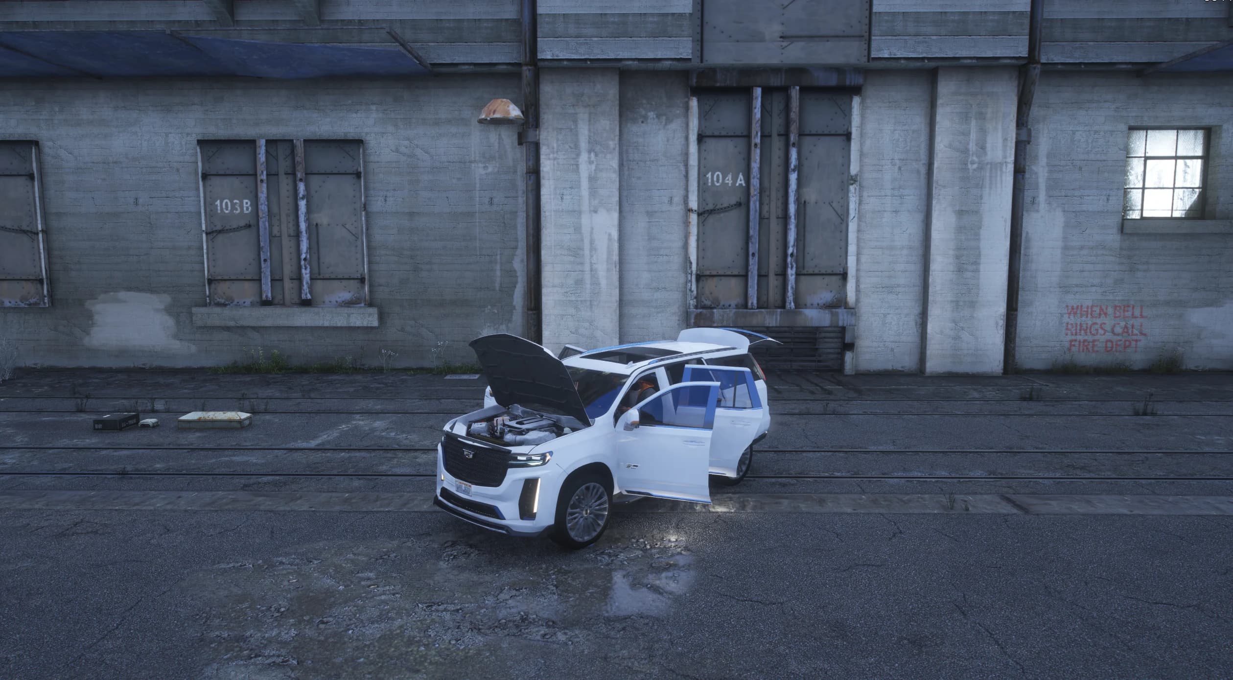Wide shot in front of old warehouse doors with the hood open over the supercharged V8 and all the doors and the tailgate open