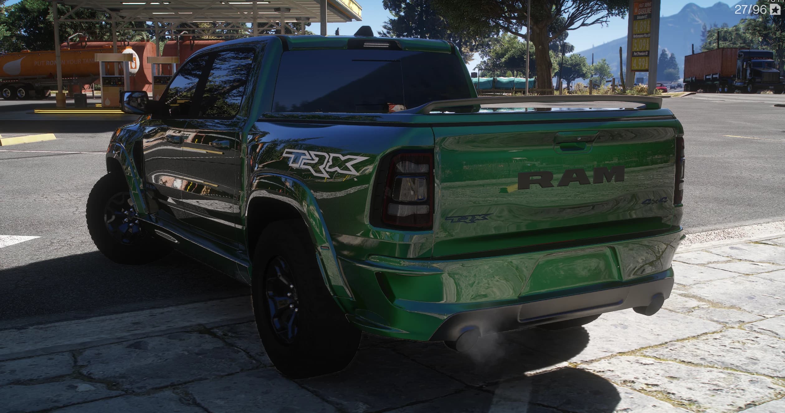 Rear three-quarter of the green TRX parked at a Fast Serve gas station, with RAM lettering on the tailgate, the 4x4 badge, a cover over the bed and exhaust smoke under the rear bumper