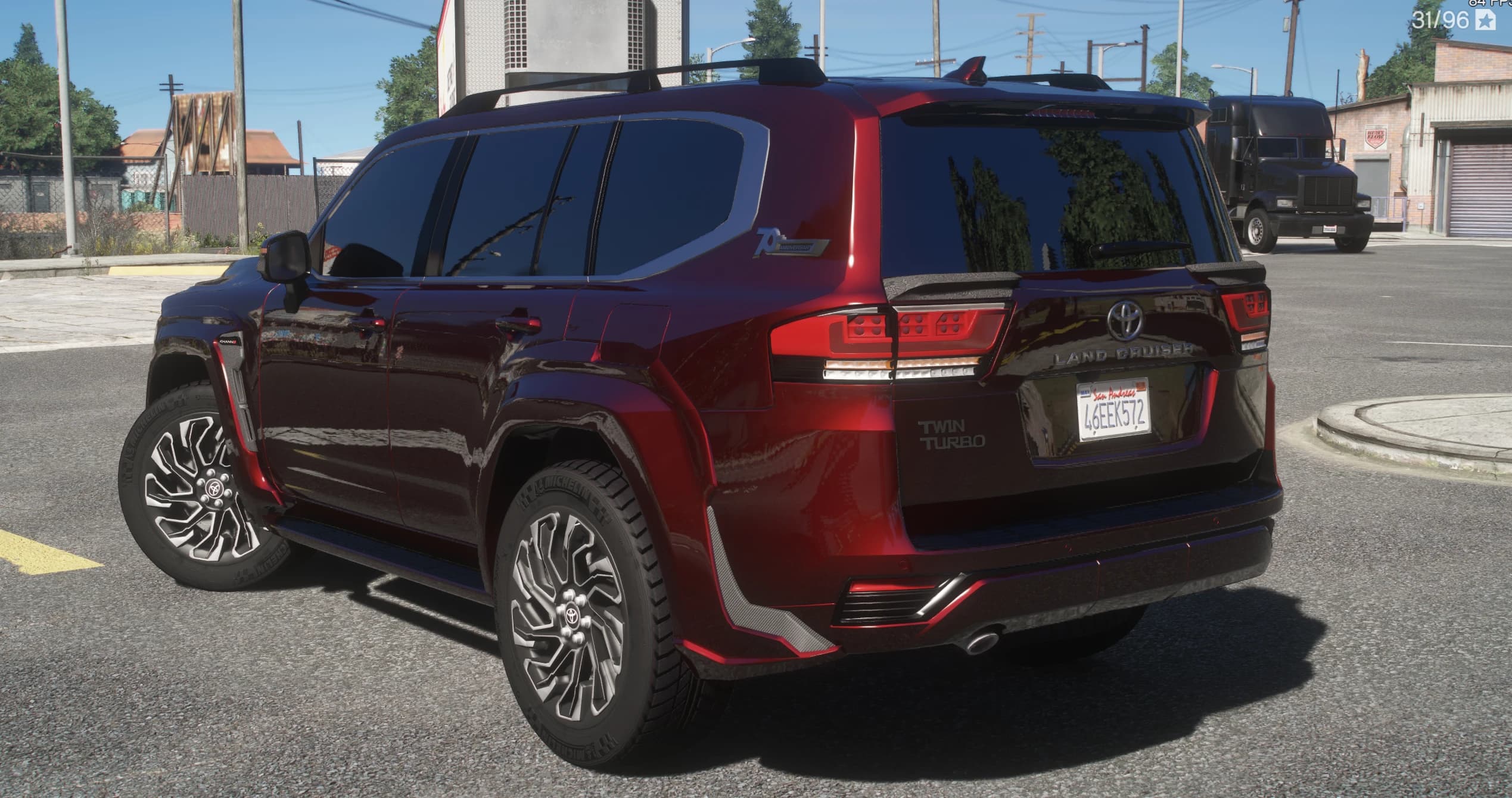 Rear three quarter view with the LAND CRUISER lettering across the tailgate, the Twin Turbo and 70th Anniversary badges and carbon accents on the bumper