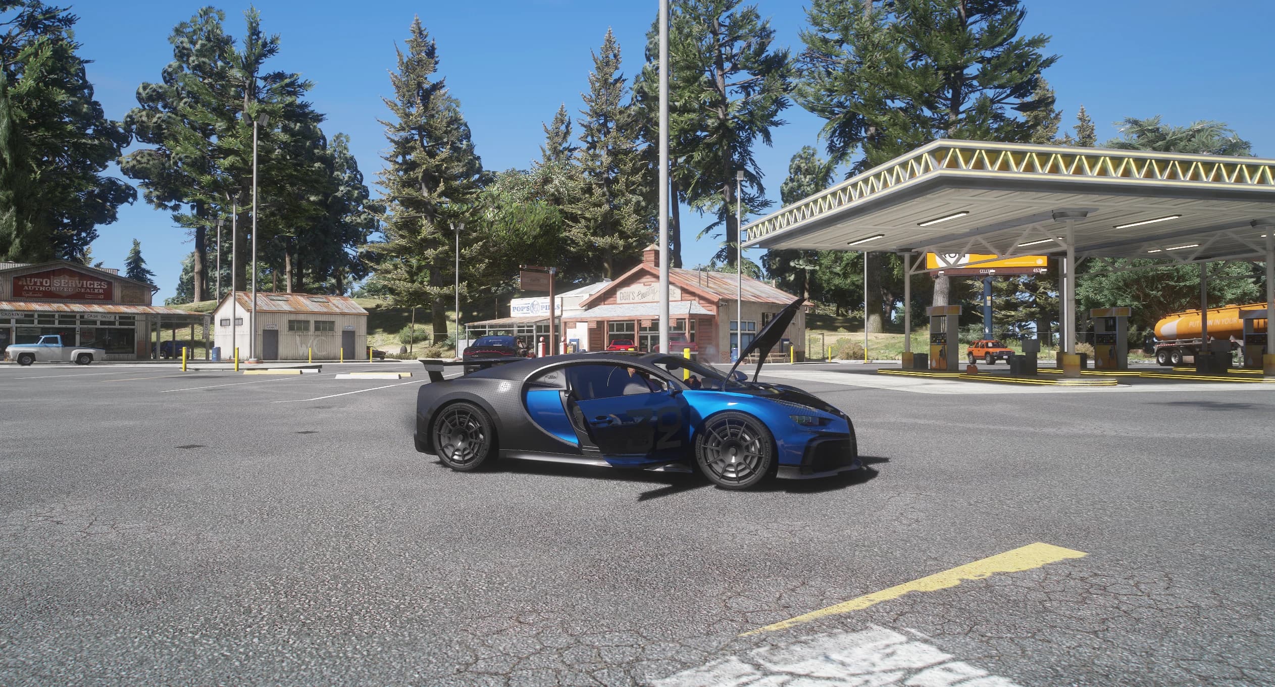 Side view of the Chiron on a rural petrol station forecourt with the driver's door and the front luggage lid open, showing the two-tone split between the blue flank and the carbon roof