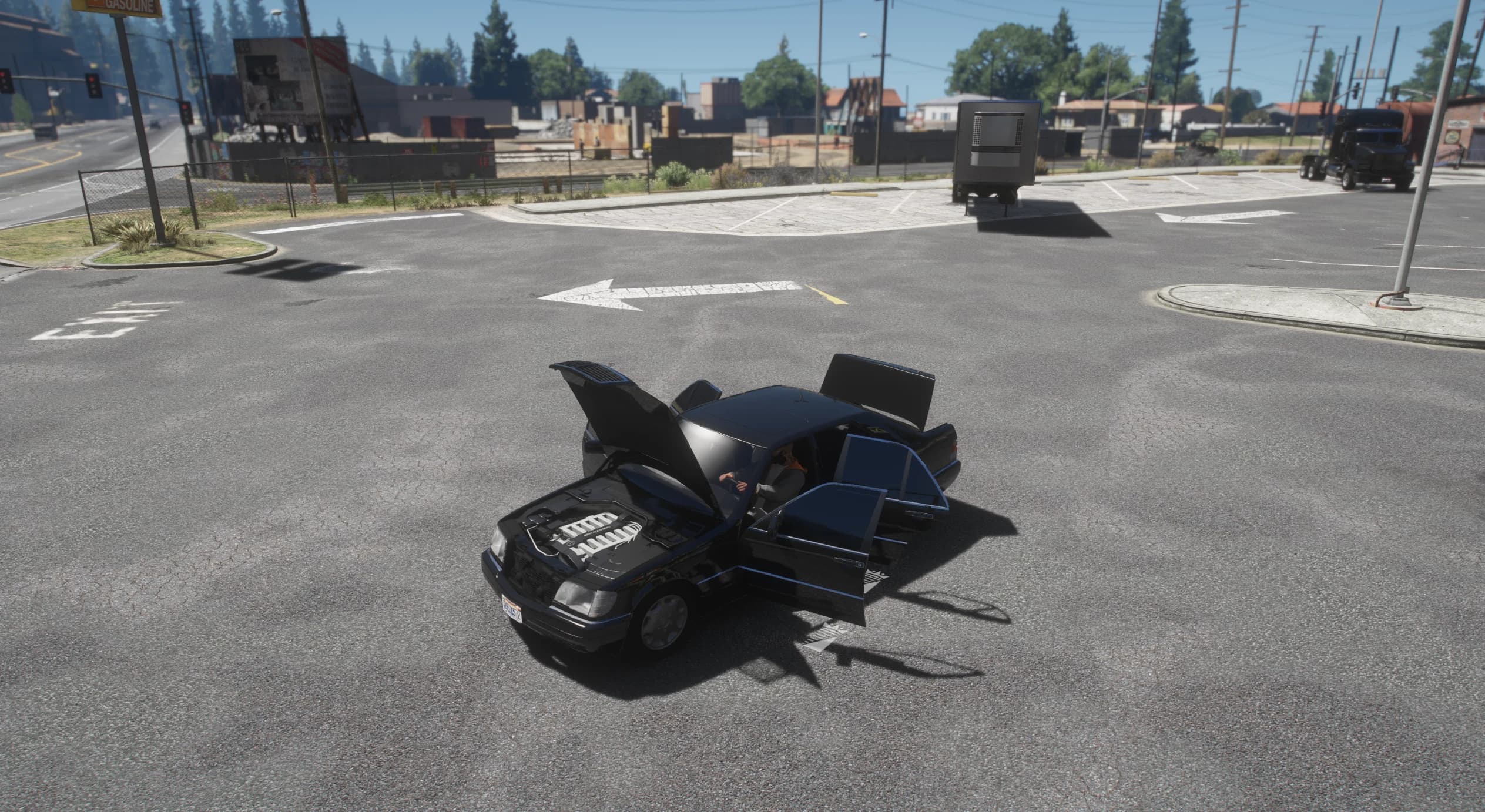 Elevated view at an intersection with the hood, the doors and the boot open, showing the V12 engine cover in the bay