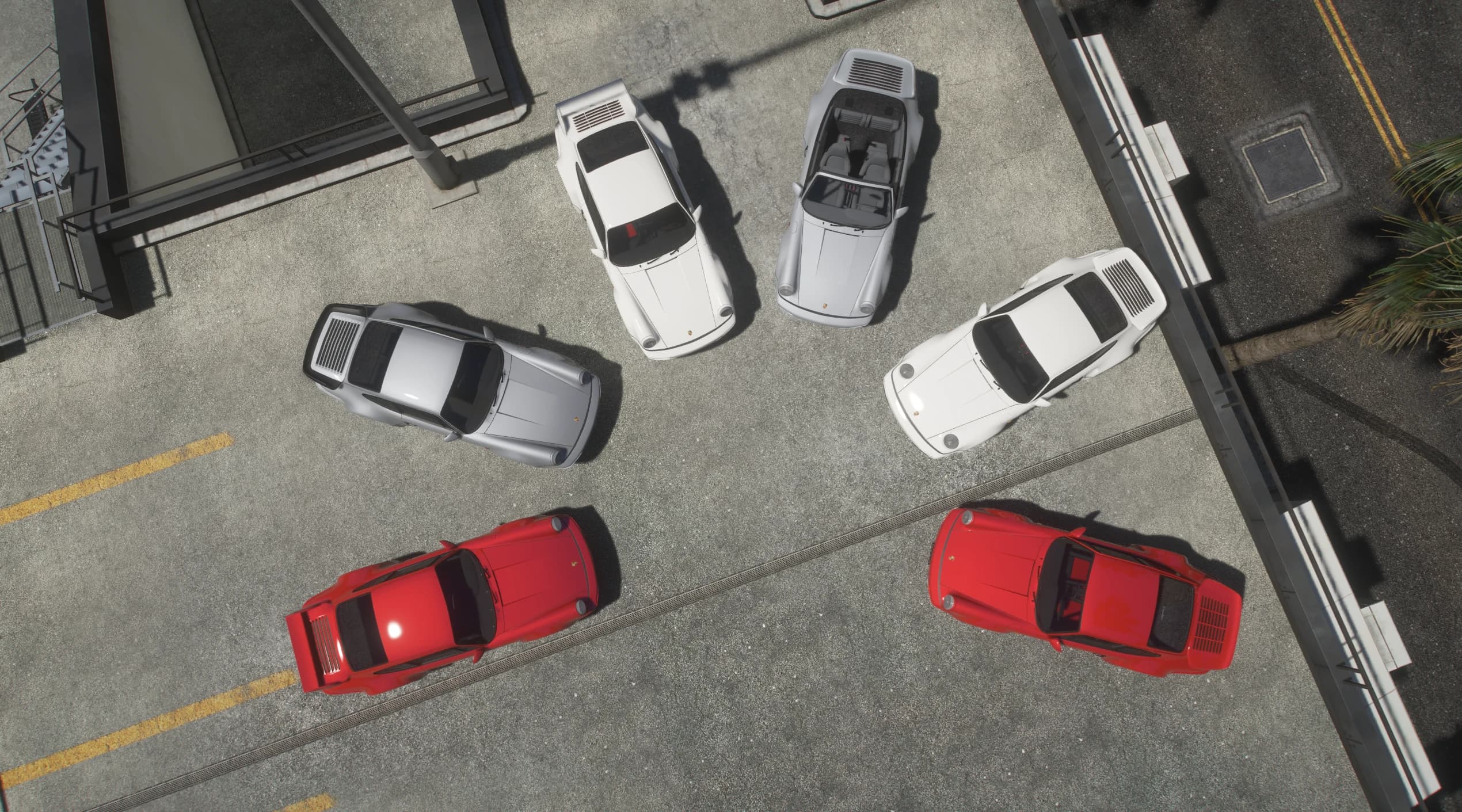 Top down view of the six 964s on a parking lot, from the open Speedster with its seats on show to the whale tail widebody Turbos in red and white