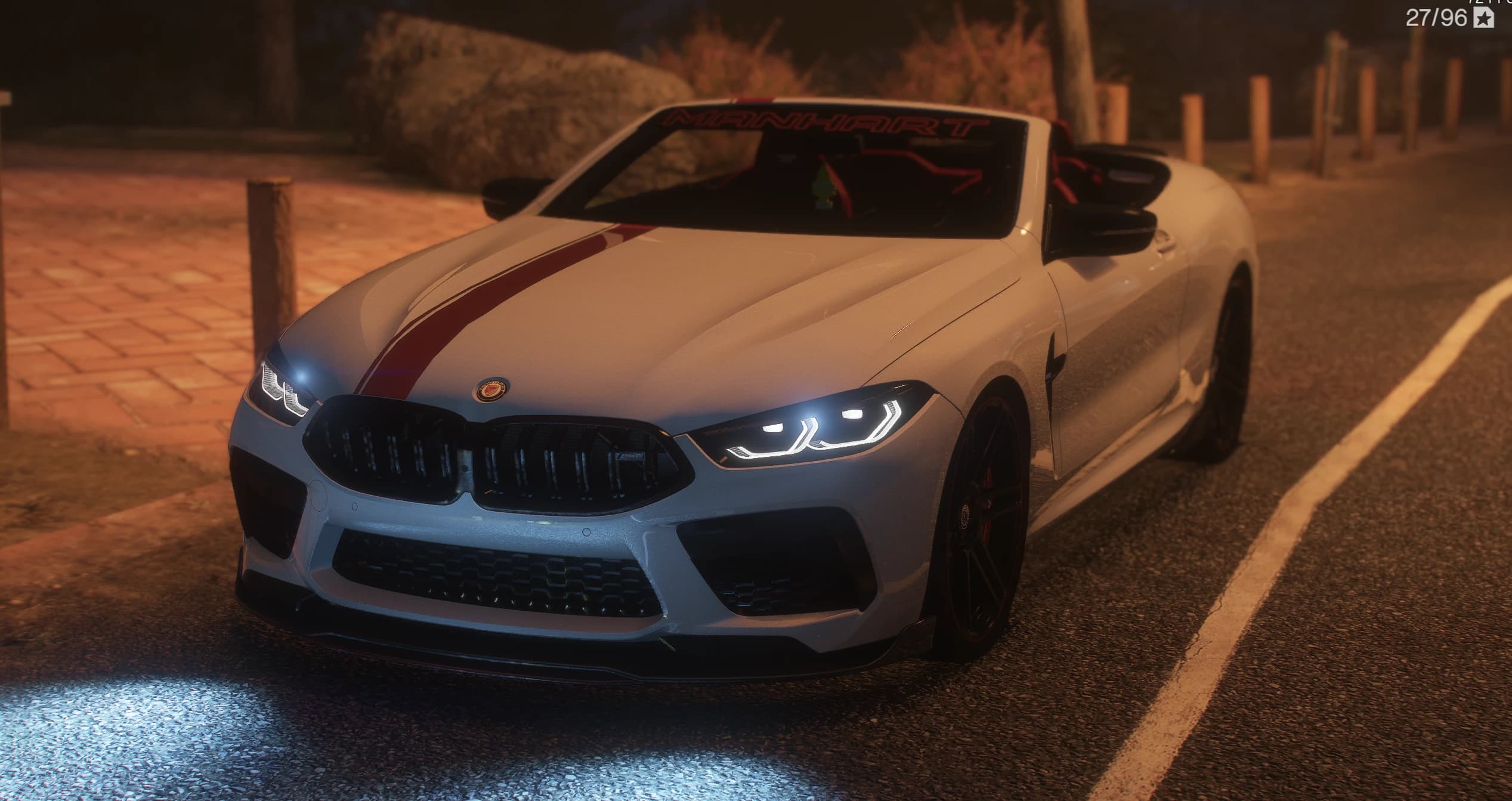 2020 Manhart MH8 800 in grey with a red centre stripe, front three-quarter at night with the top down, black kidney grille, laser headlights lit and a MANHART banner across the top of the windscreen
