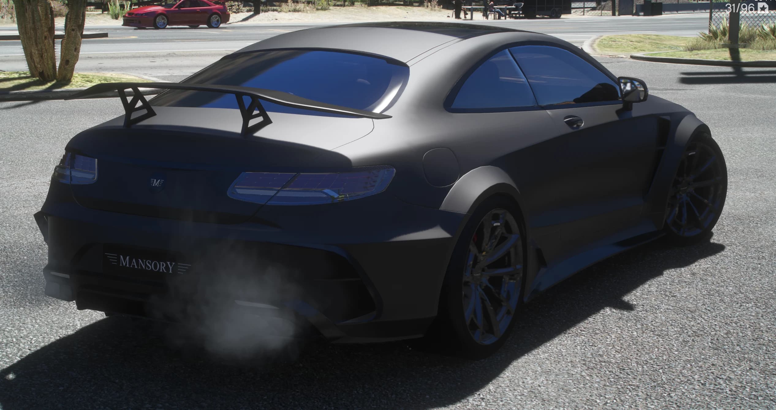 Rear three quarter view in the shade with the tall GT wing on angular struts, the MANSORY frame on the bumper and exhaust smoke drifting from the diffuser