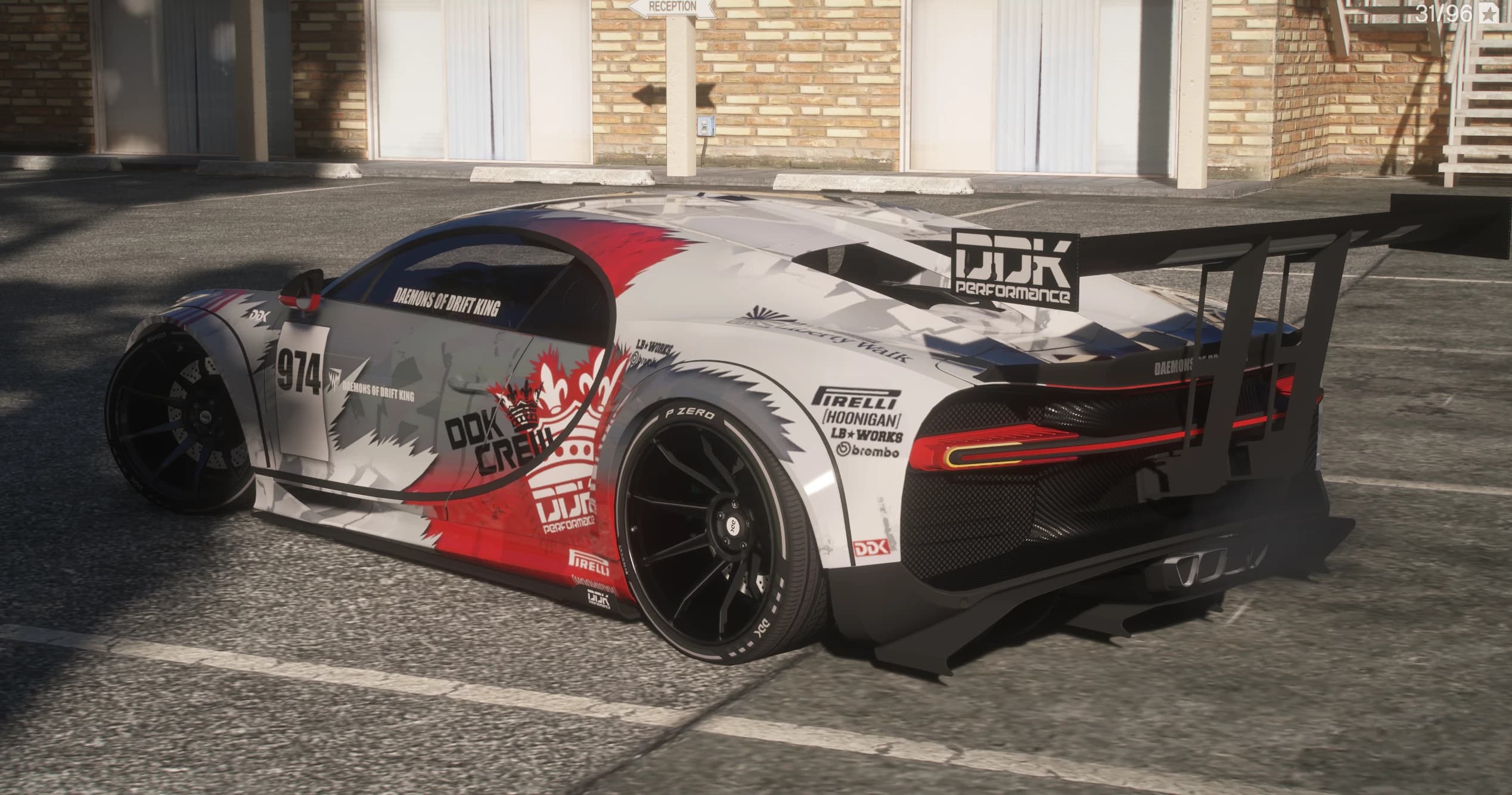 Rear three quarter view showing the full width red taillight bar, the carbon diffuser, sponsor decals on the rear arch and the chassis mounted wing with the DDK Performance panel