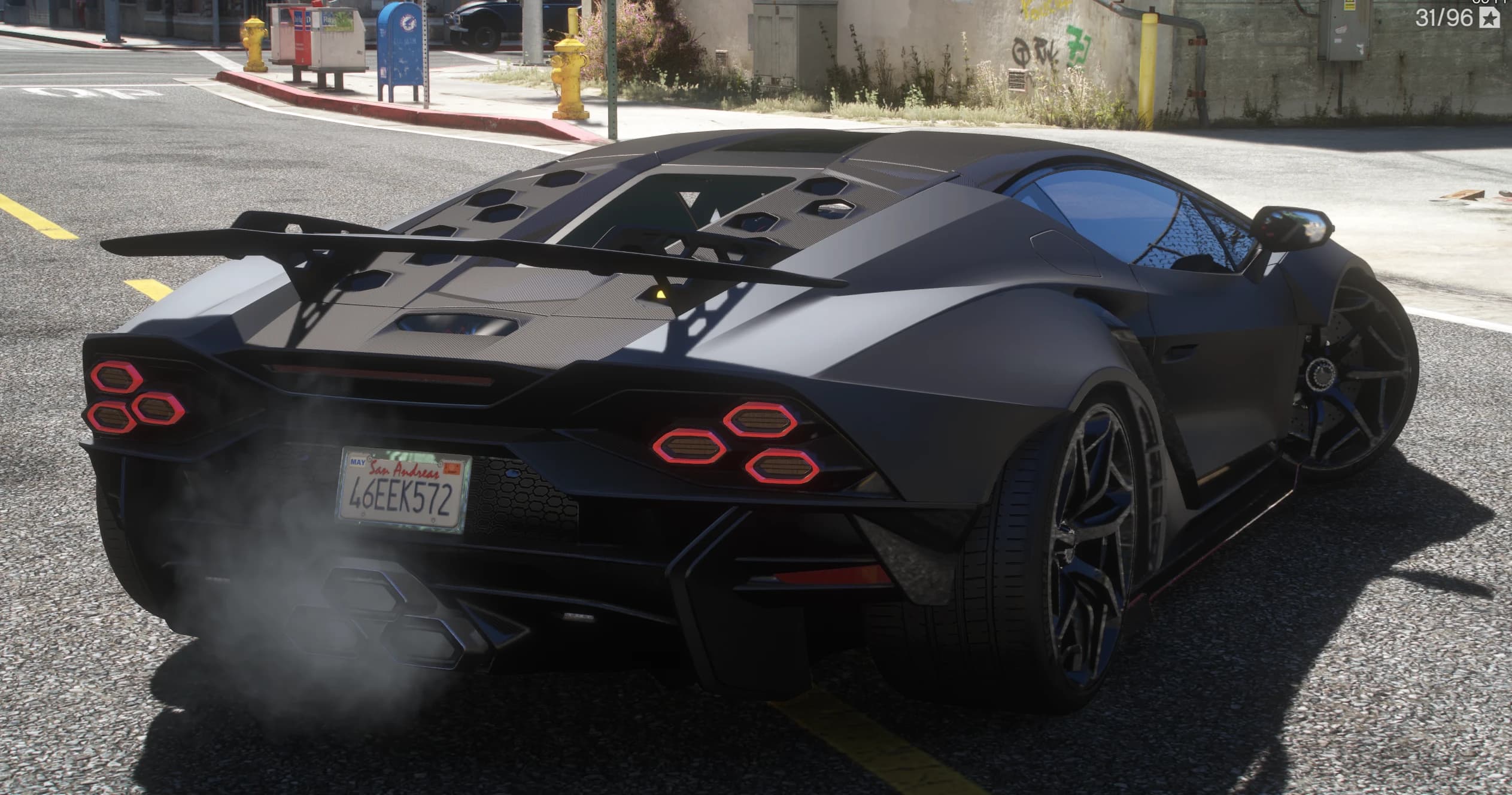 Rear view showing the triple hexagonal taillights on each side, the perforated carbon engine cover and the stacked hexagon exhaust tips over the diffuser