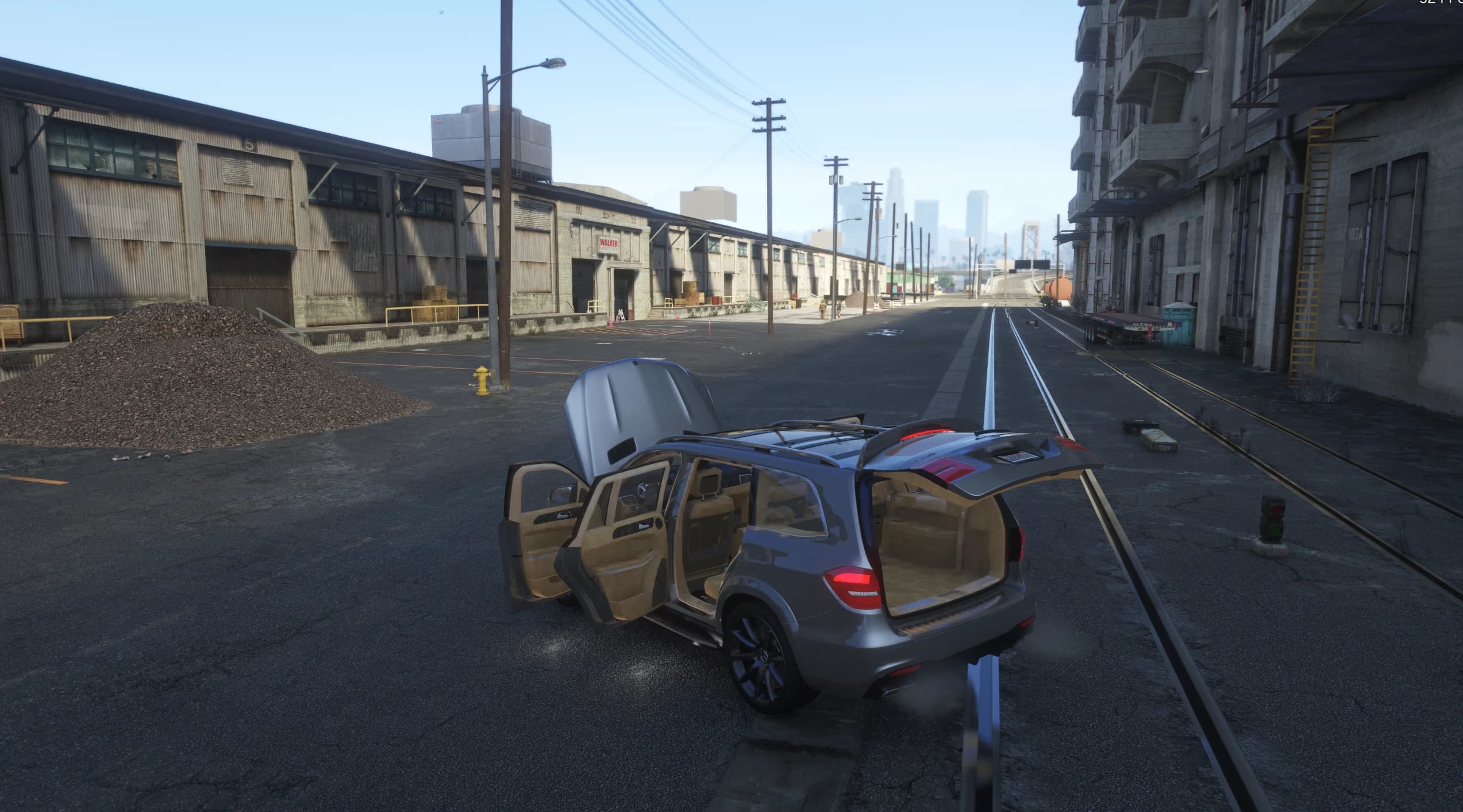 The SUV parked on an industrial street with all doors, the bonnet and the tailgate open over the tan seven seat interior