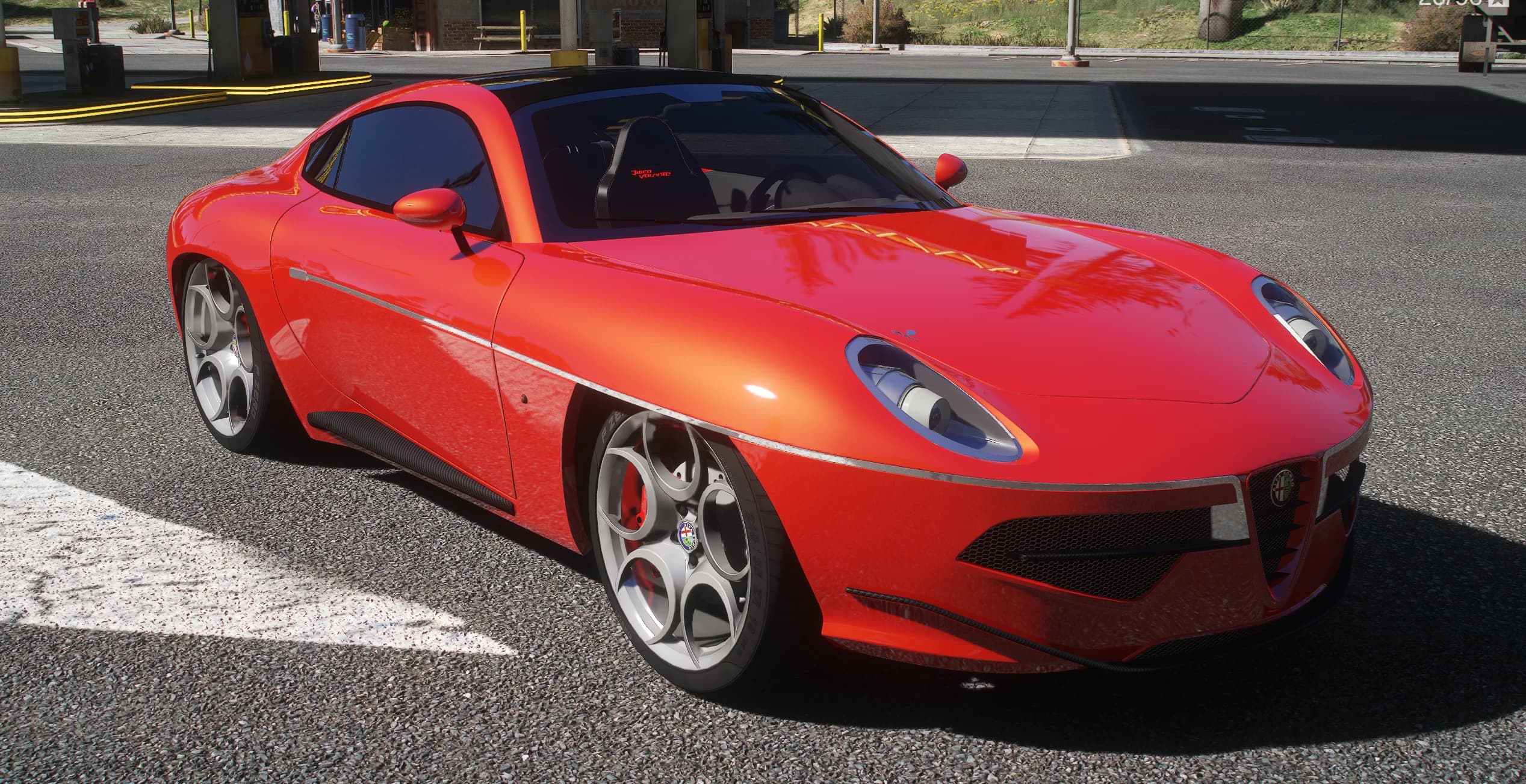 Red Alfa Romeo Disco Volante coupe with black roof, Alfa Romeo grille shield and silver five-hole wheels, front three-quarter view at a gas station