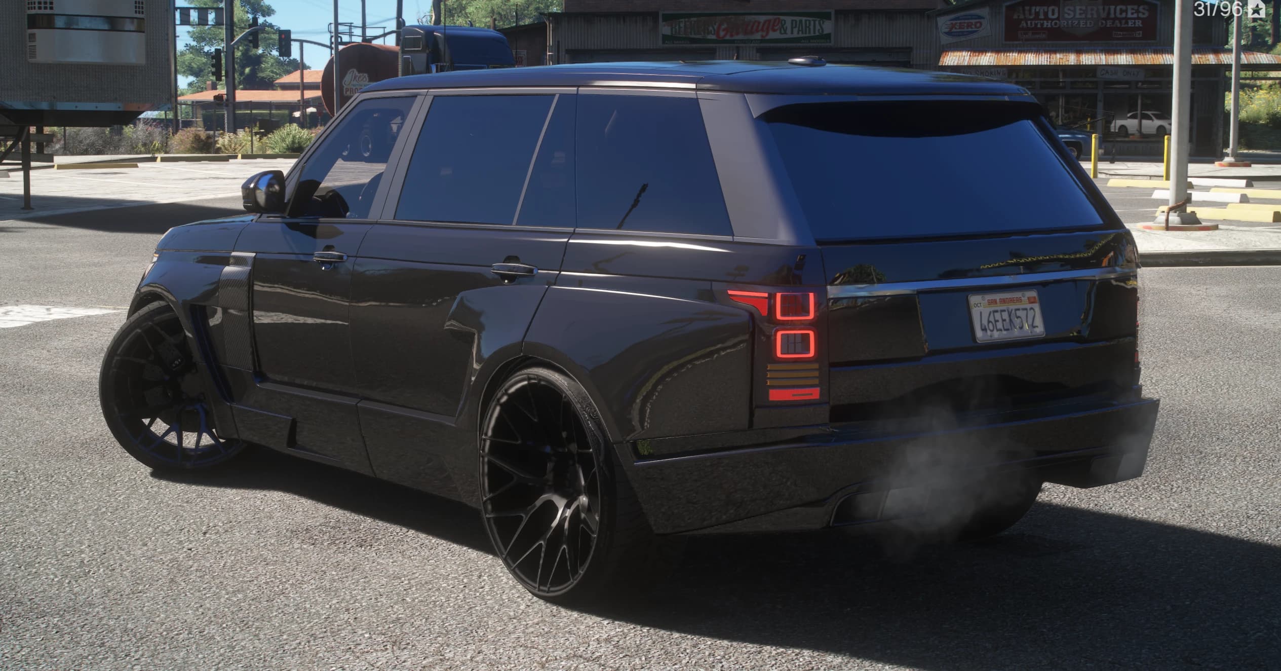 Rear three quarter view by roadside shops showing the widened arches, red square taillights and the San Andreas plate on the tailgate