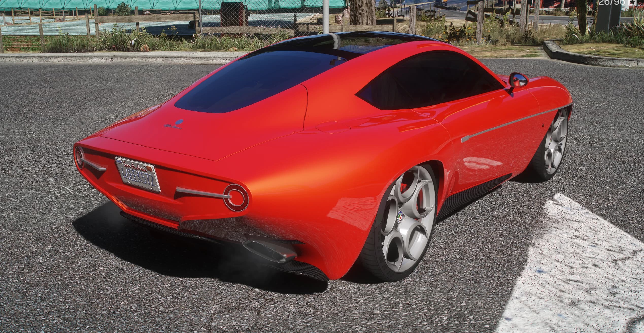 Rear three-quarter of the red Disco Volante showing the rounded tail, twin circular taillights and the Touring Superleggera badge