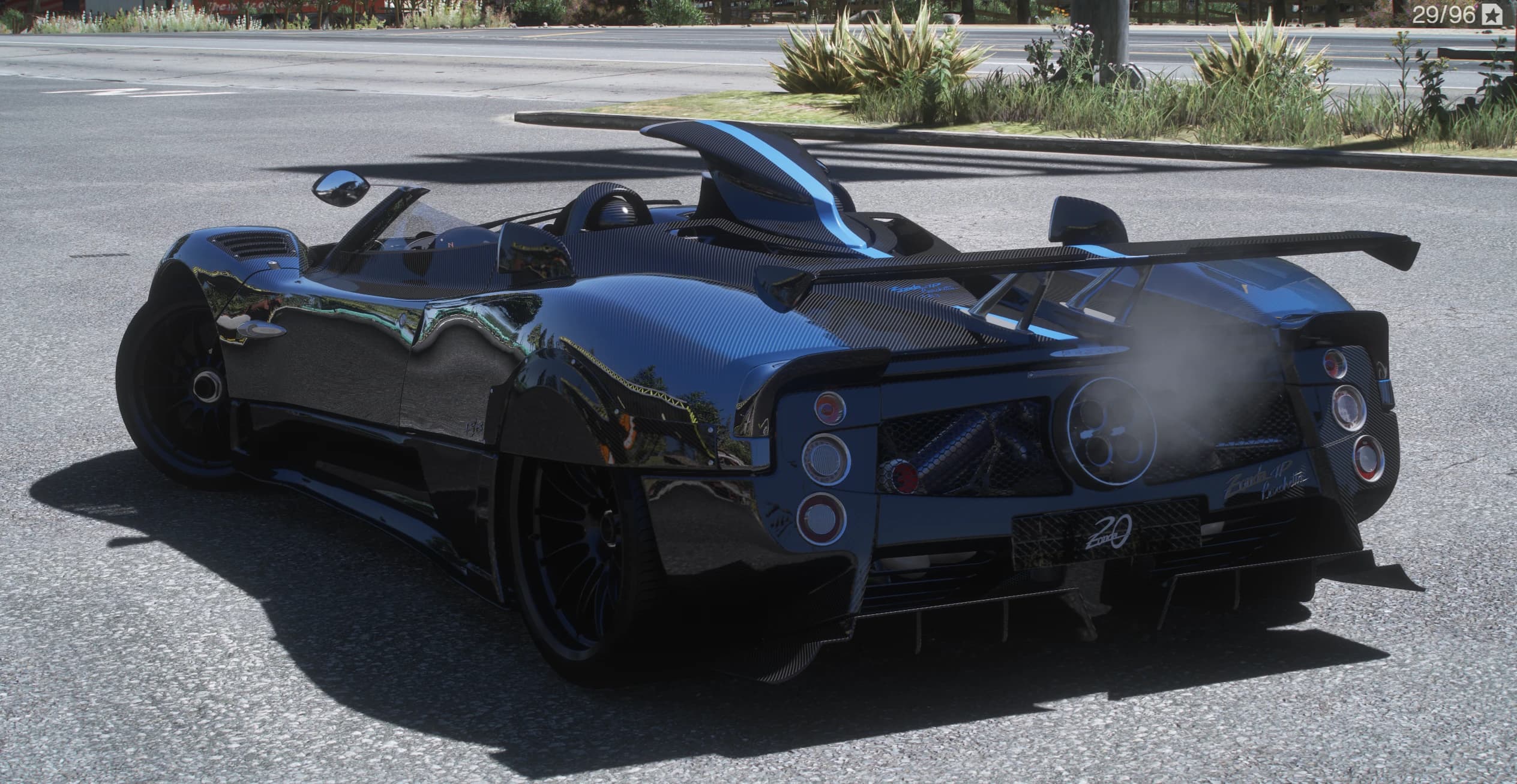 Rear three-quarter of the Zonda HP Barchetta showing the four round taillights, the big rear wing, the quad centre exhaust and the 20th-anniversary badging