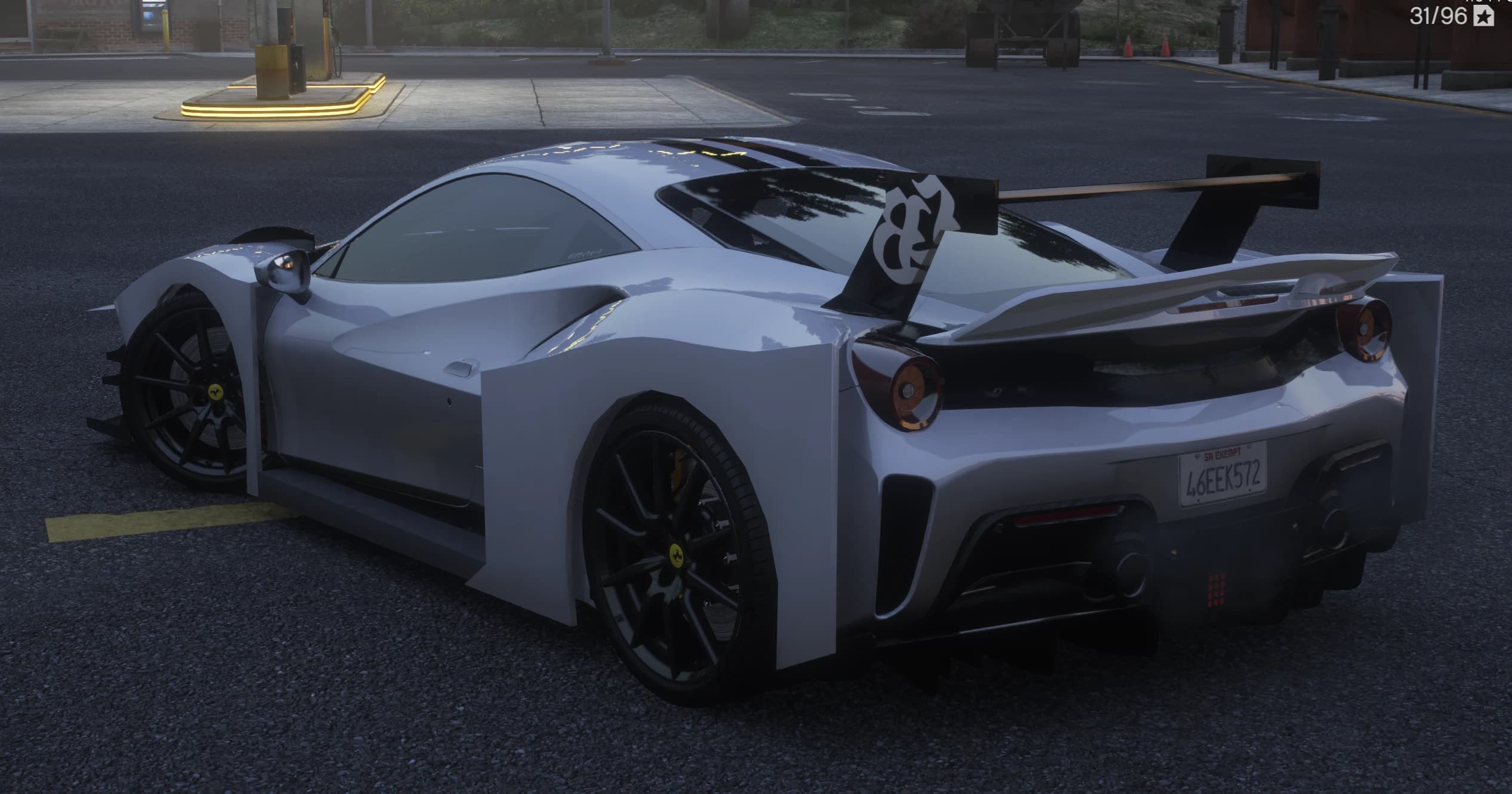 Rear three quarter view by a gas station showing the chassis mounted GT wing with the LB emblem, round taillights, boxy rear arches and a San Andreas plate