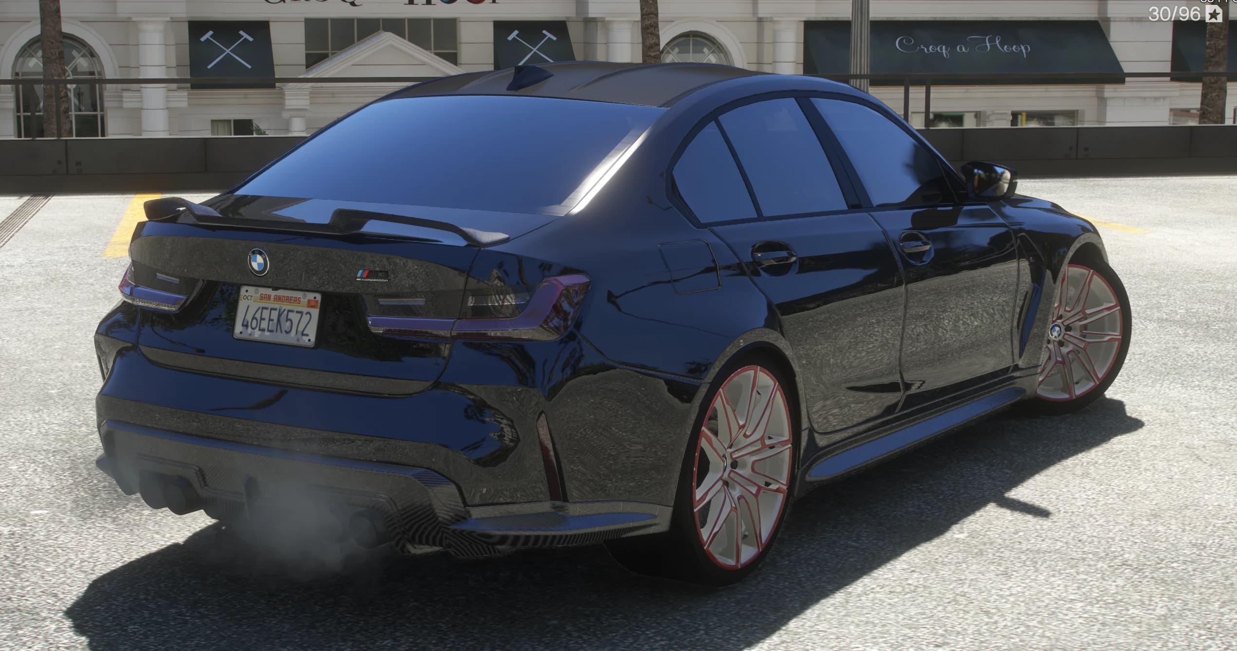 Rear three-quarter of the black M3 Vorsteiner with a ducktail lip spoiler and quad exhausts blowing smoke, San Andreas plate visible
