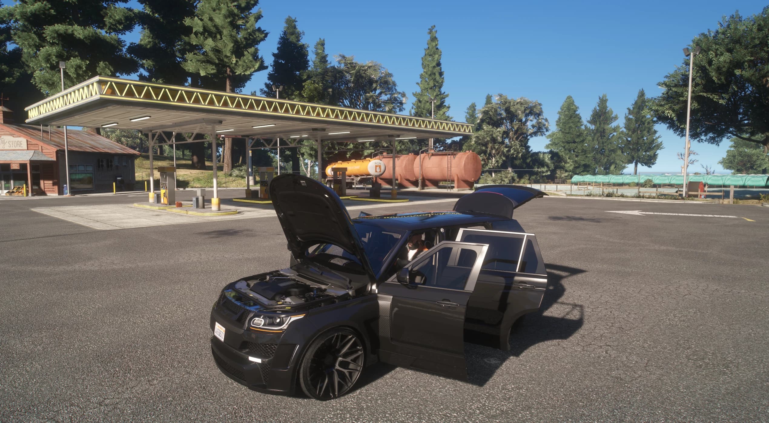 The Range Rover at a forest gas station with the hood over the modelled engine bay, a rear door and the split tailgate open