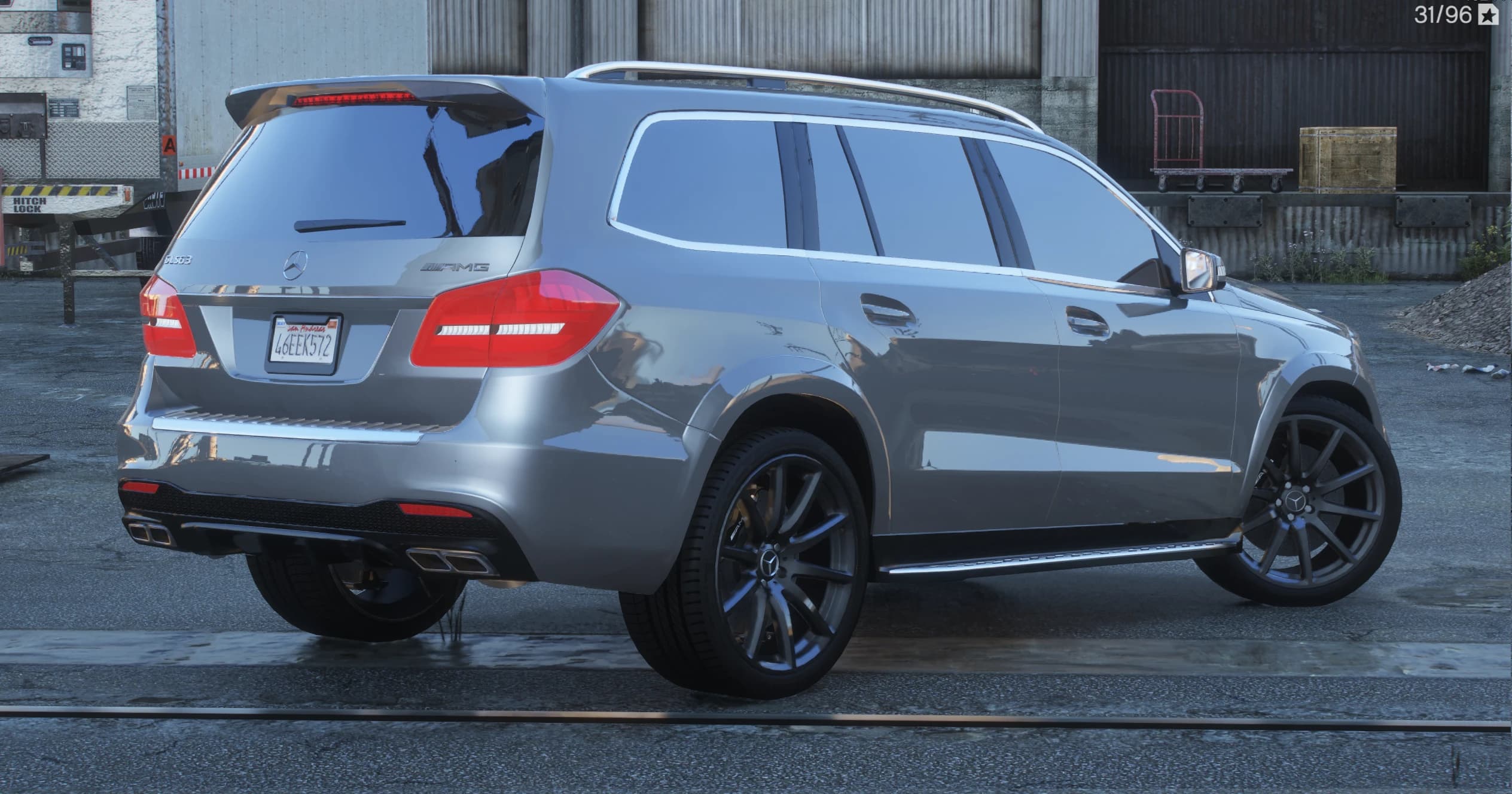 Rear three quarter view showing the GLS63 and AMG badges, the roof spoiler and four chrome square exhaust tips