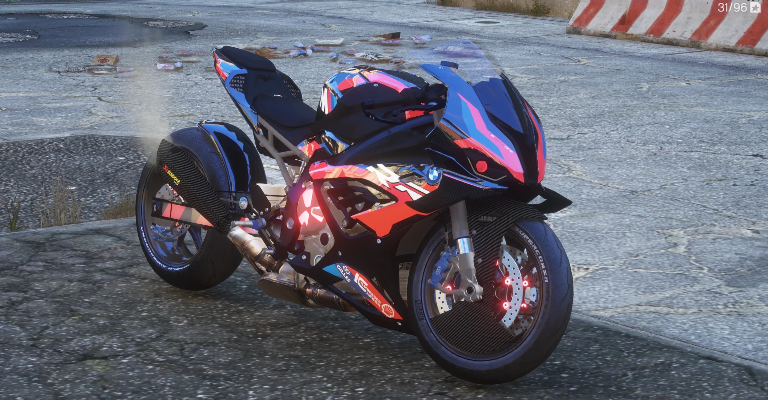 Front three quarter view of the stretched M1000RR in a chrome blue, pink and red wrap with a glowing red engine emblem and carbon wheels