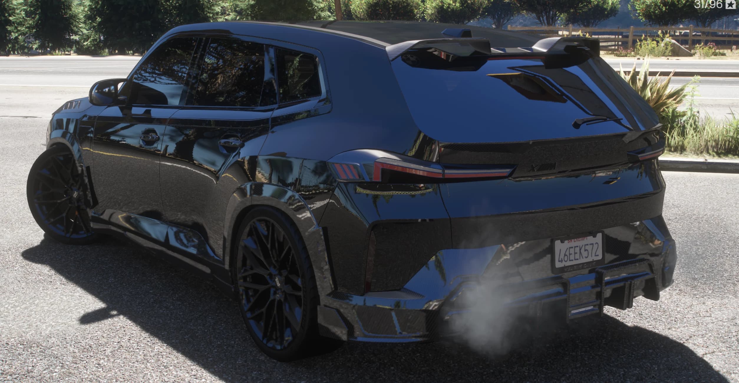 Rear three quarter view showing the double roof spoiler, carbon arches, XM taillights and the finned carbon diffuser