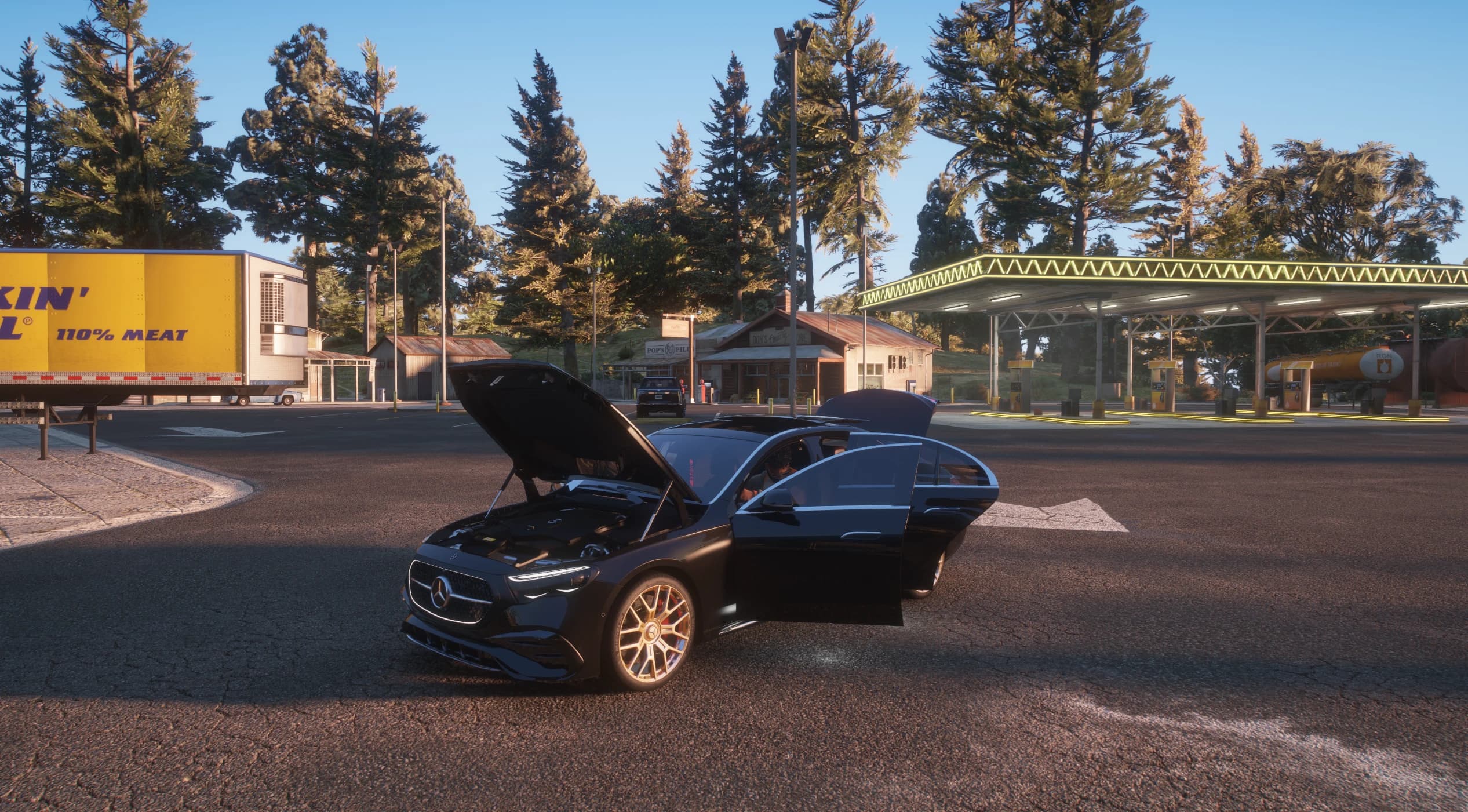 The E350 with the bonnet and a door open at a rural gas station at sunset, showing the modelled engine bay