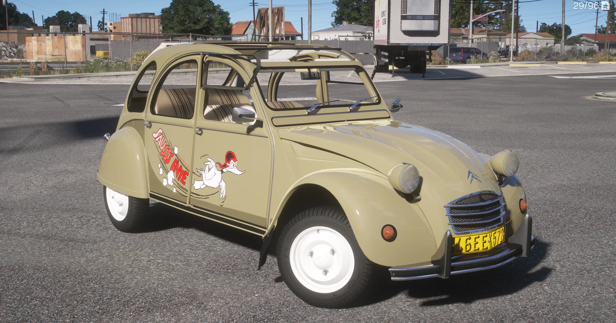 Sand-beige Citroen 2CV with the 'Saussss Ente' cartoon duck livery on the door and the canvas roof rolled open, in an industrial lot