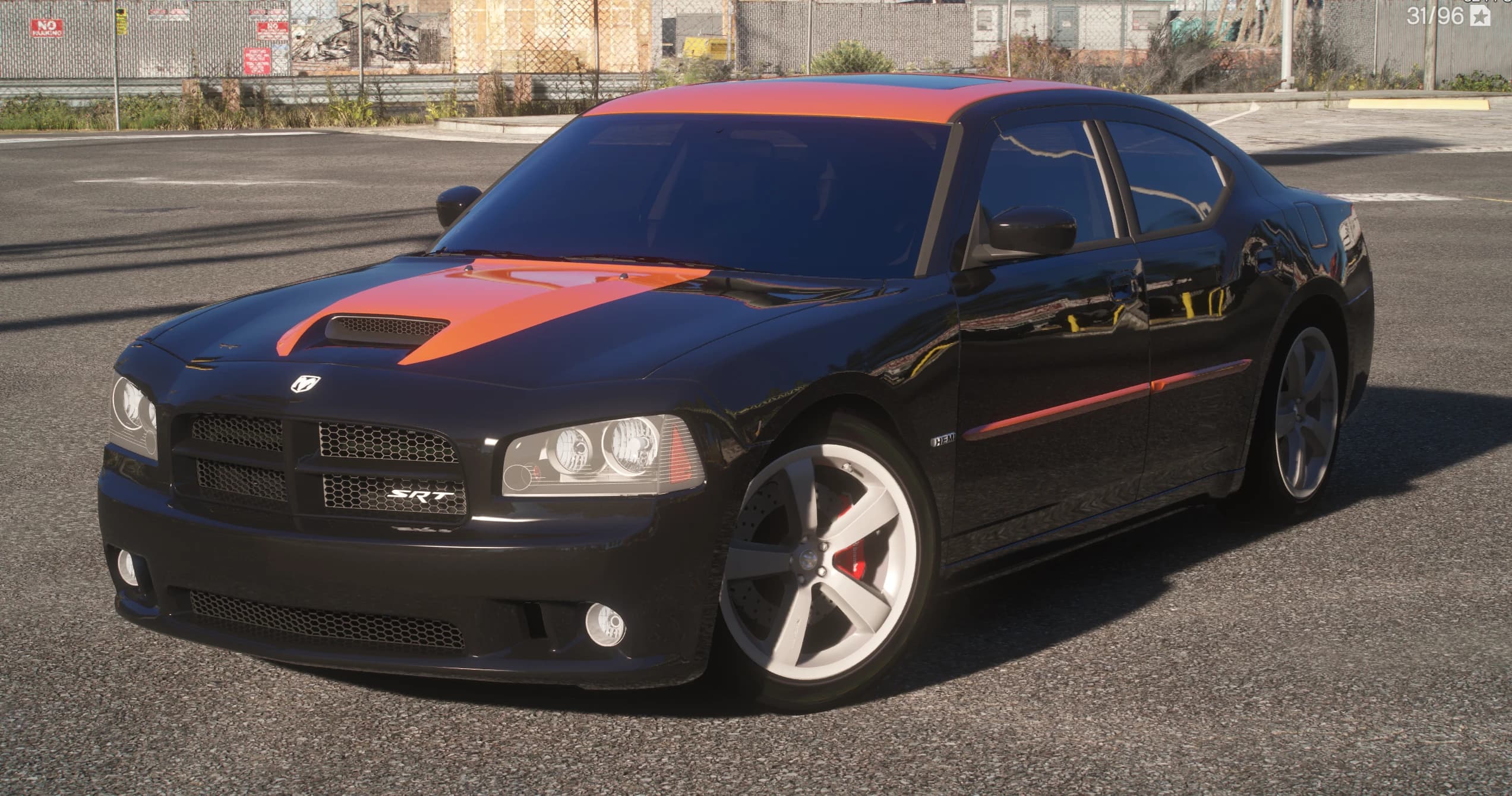 Front three quarter view of the black Charger SRT8 with the orange hood scoop stripe, the SRT badge in the crosshair grille and red calipers behind silver five spoke wheels