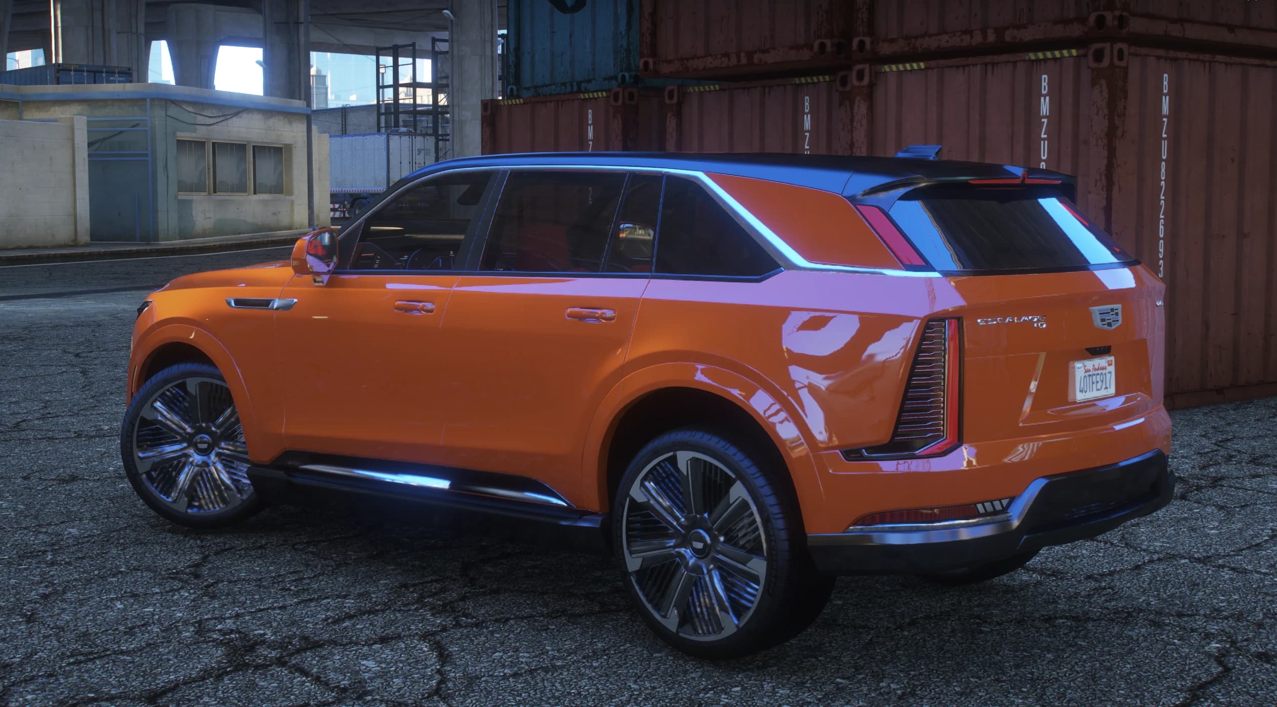 Rear three quarter view showing the Escalade IQ tailgate lettering, split vertical taillights and the red cabin through the glass
