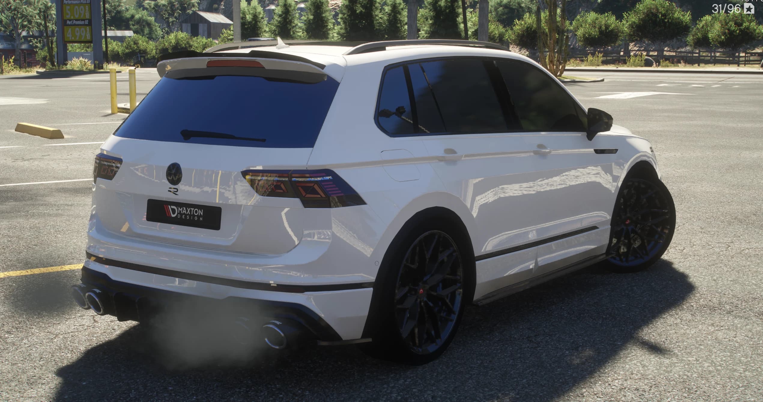 Rear three quarter at a gas station showing the roof spoiler, the smoked tail lights, the Maxton Design rear plate and the quad exhaust tips with smoke