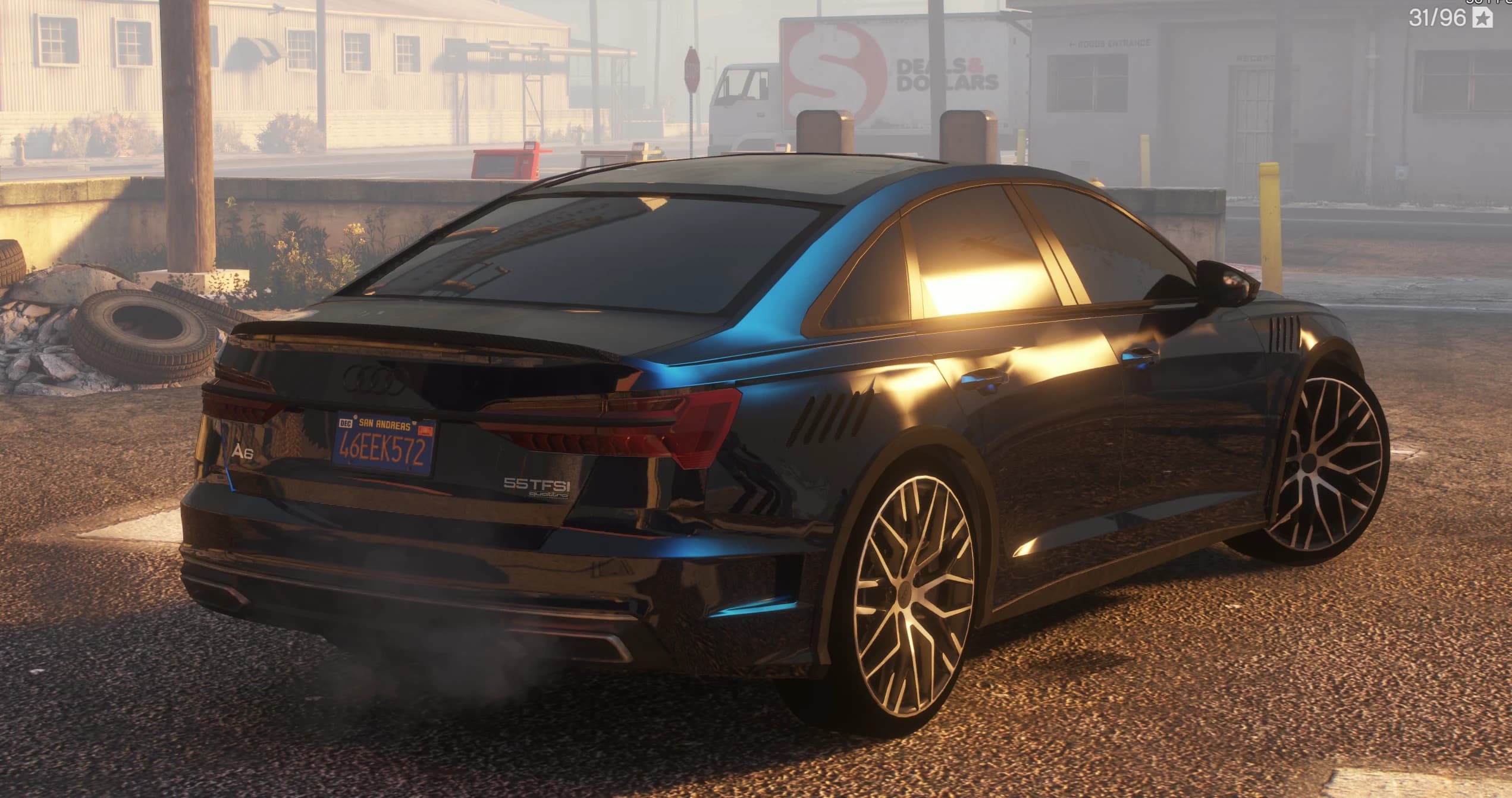 Rear three quarter view at sunset showing the A6 and 55 TFSI quattro badges, the carbon boot lip spoiler and the side vents behind the front wheels