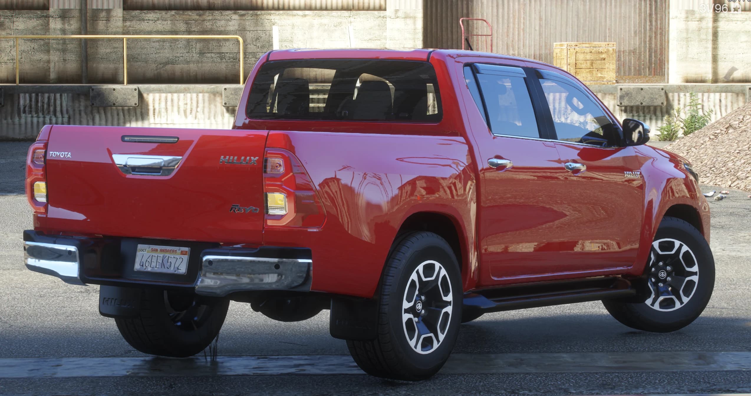 Rear three quarter view showing the Toyota stamped tailgate with chrome handle, Hilux and Revo badges, chrome bumper and Hilux mudflaps