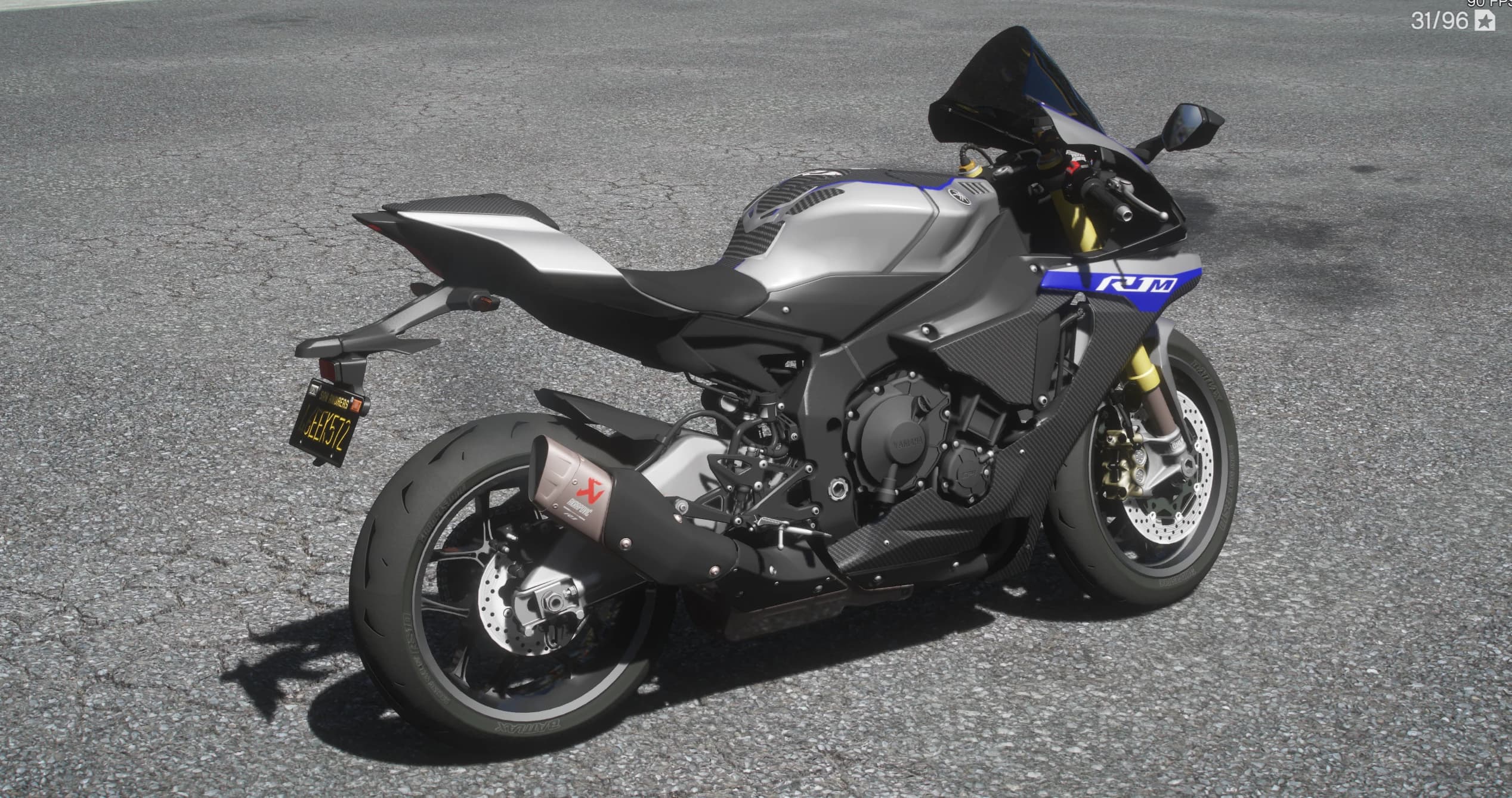 Rear three quarter view of the R1M showing the titanium Akrapovic silencer, the black San Andreas plate and the carbon panels over the tank