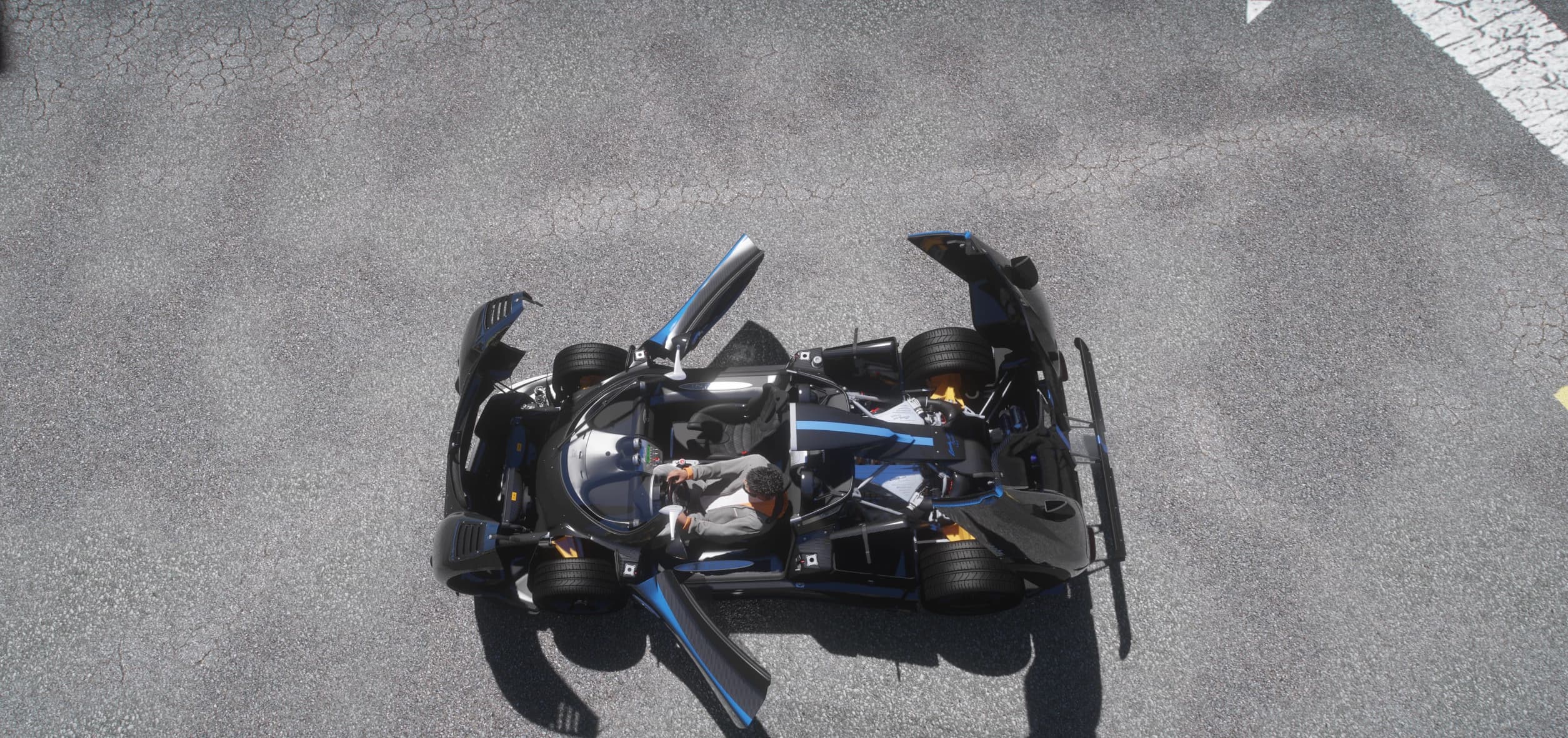 Top-down view of the Zonda with both gullwing doors open and the driver in the open cockpit