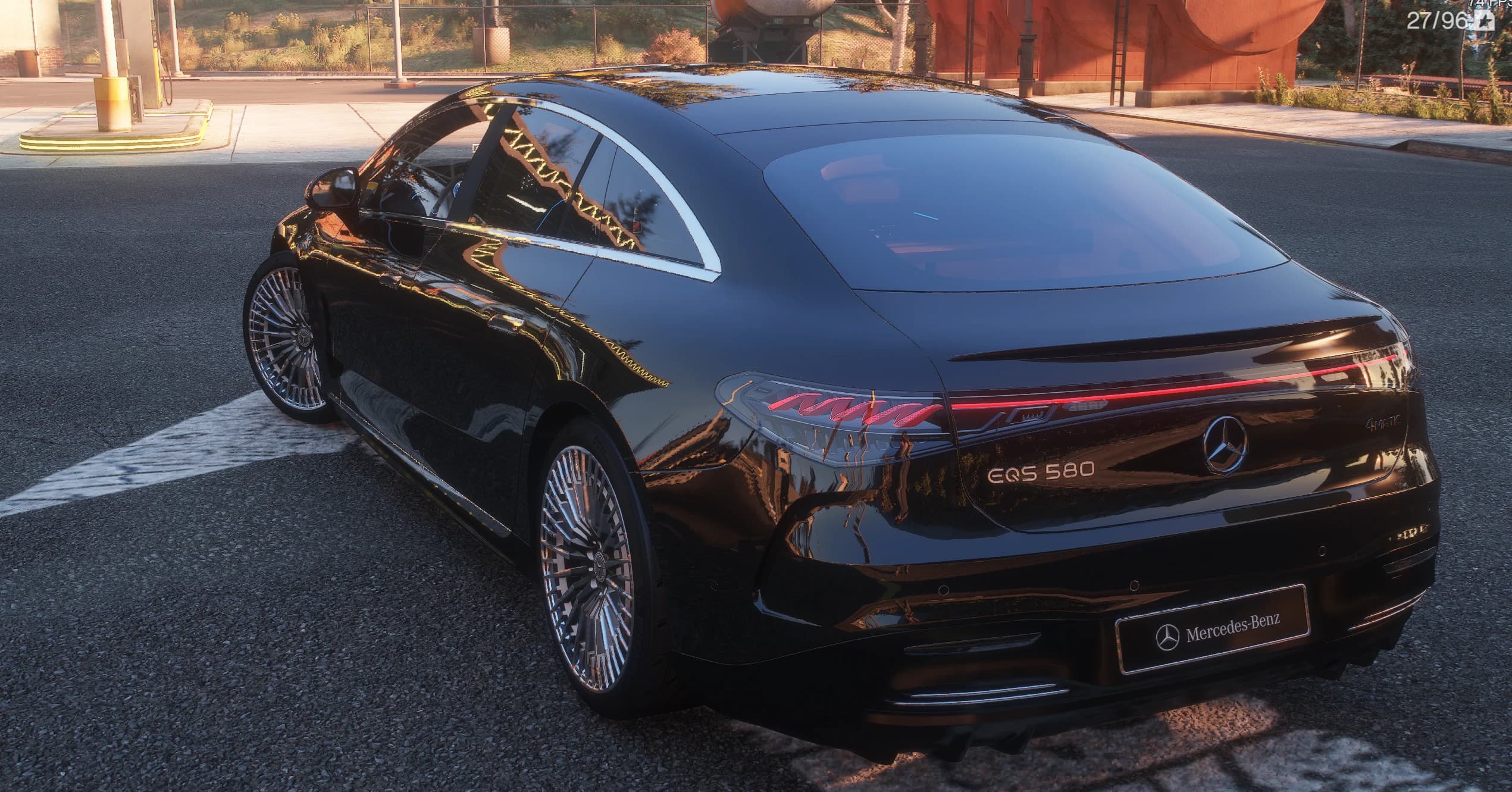 Rear three-quarter of the black EQS showing the full-width red tail light bar with its detailed pattern, the EQS 580 and 4MATIC badges and a Mercedes-Benz show plate