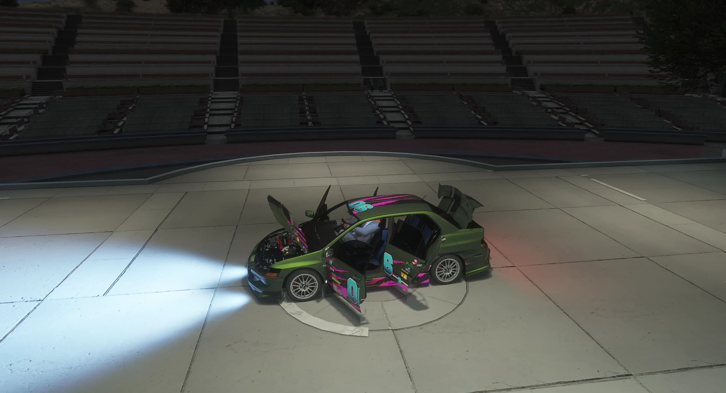 Night shot taken from above in the Vinewood amphitheatre with the bonnet, both left doors and the boot open, the driver sitting inside and the headlights lit