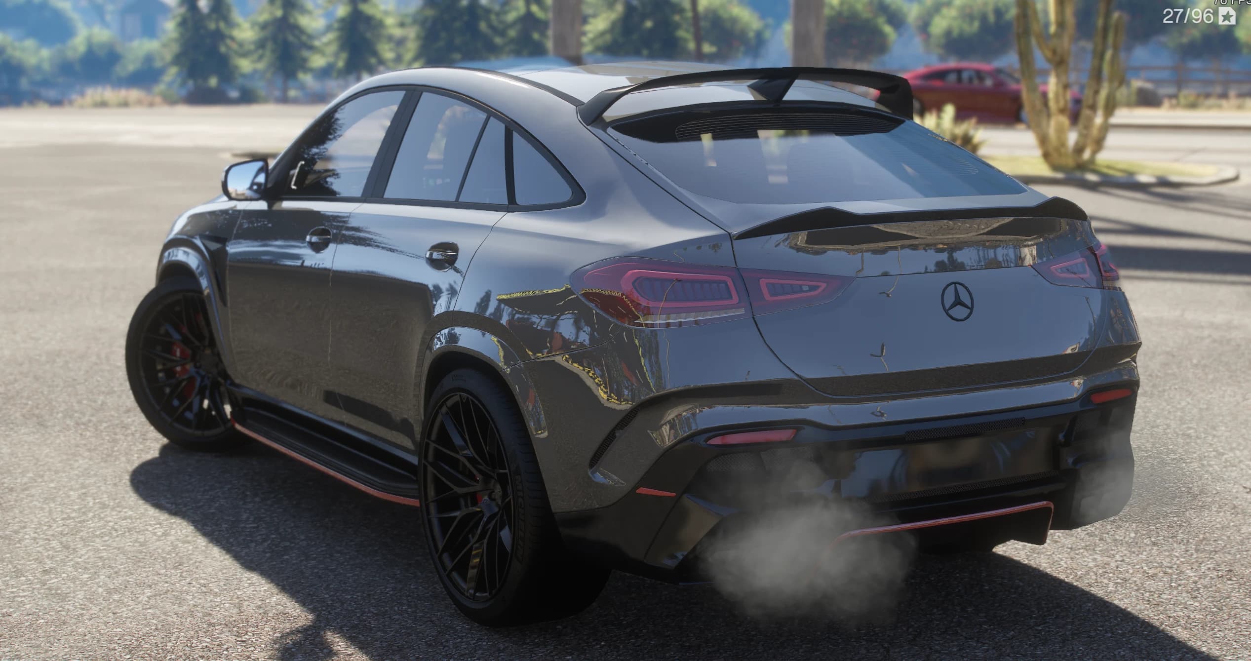 Rear three-quarter of the GLE showing the sloping coupe roofline, the roof spoiler and the boot lip spoiler, the star on the tailgate, the LED tail lights and exhaust smoke over the red-trimmed diffuser