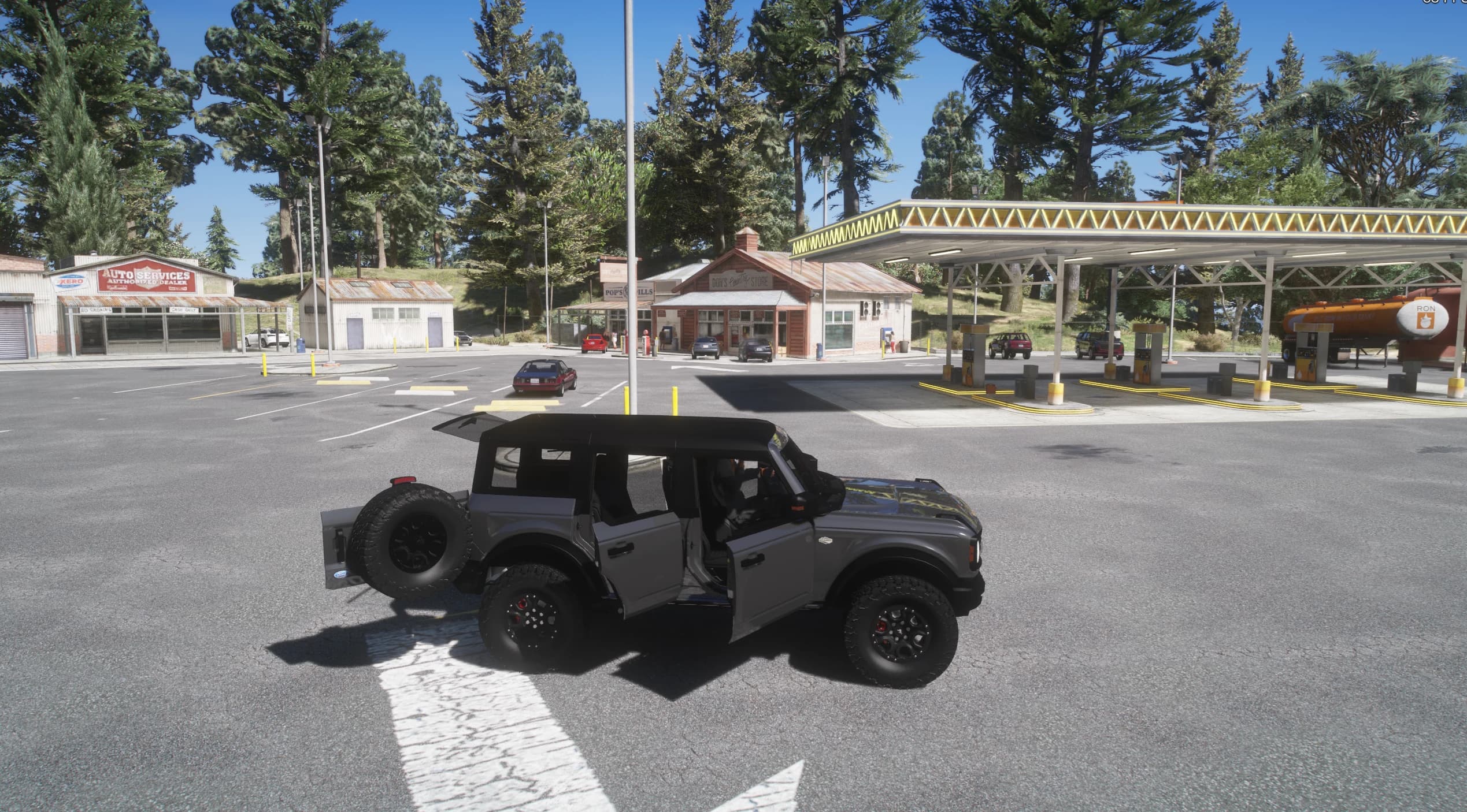 Side view of the grey Bronco with its doors open at a rural gas station