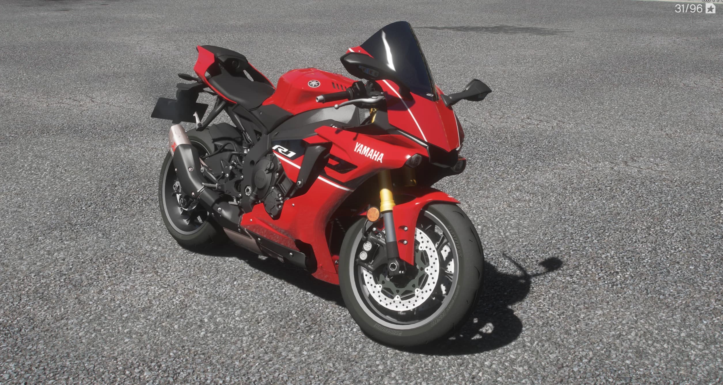 Front three quarter view of the red R1 with the Yamaha logo on the fairing, smoked windscreen, gold forks and drilled twin front brake discs