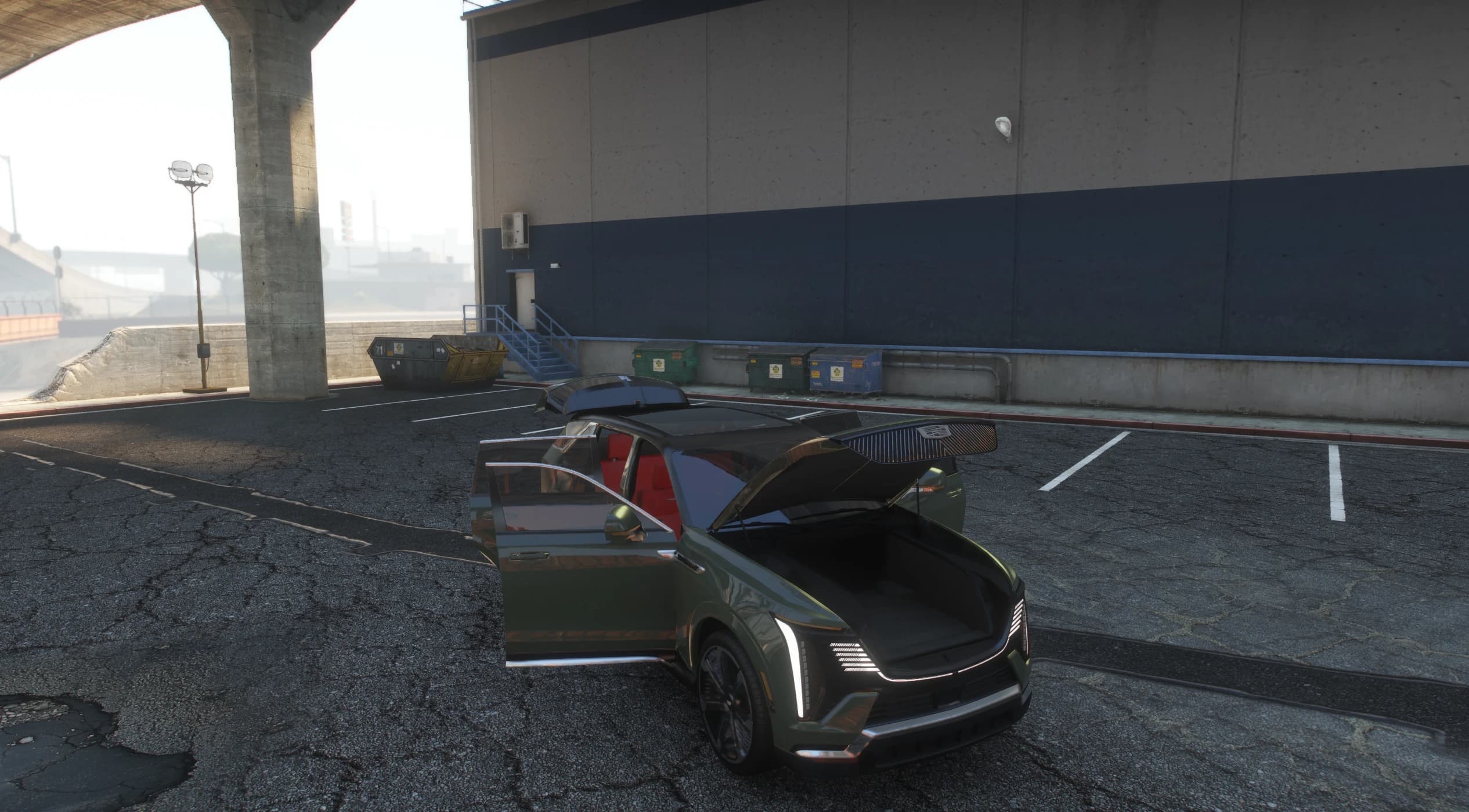 Dark green Escalade IQ with the driver door open and the powered hood raised over the front trunk, red leather inside