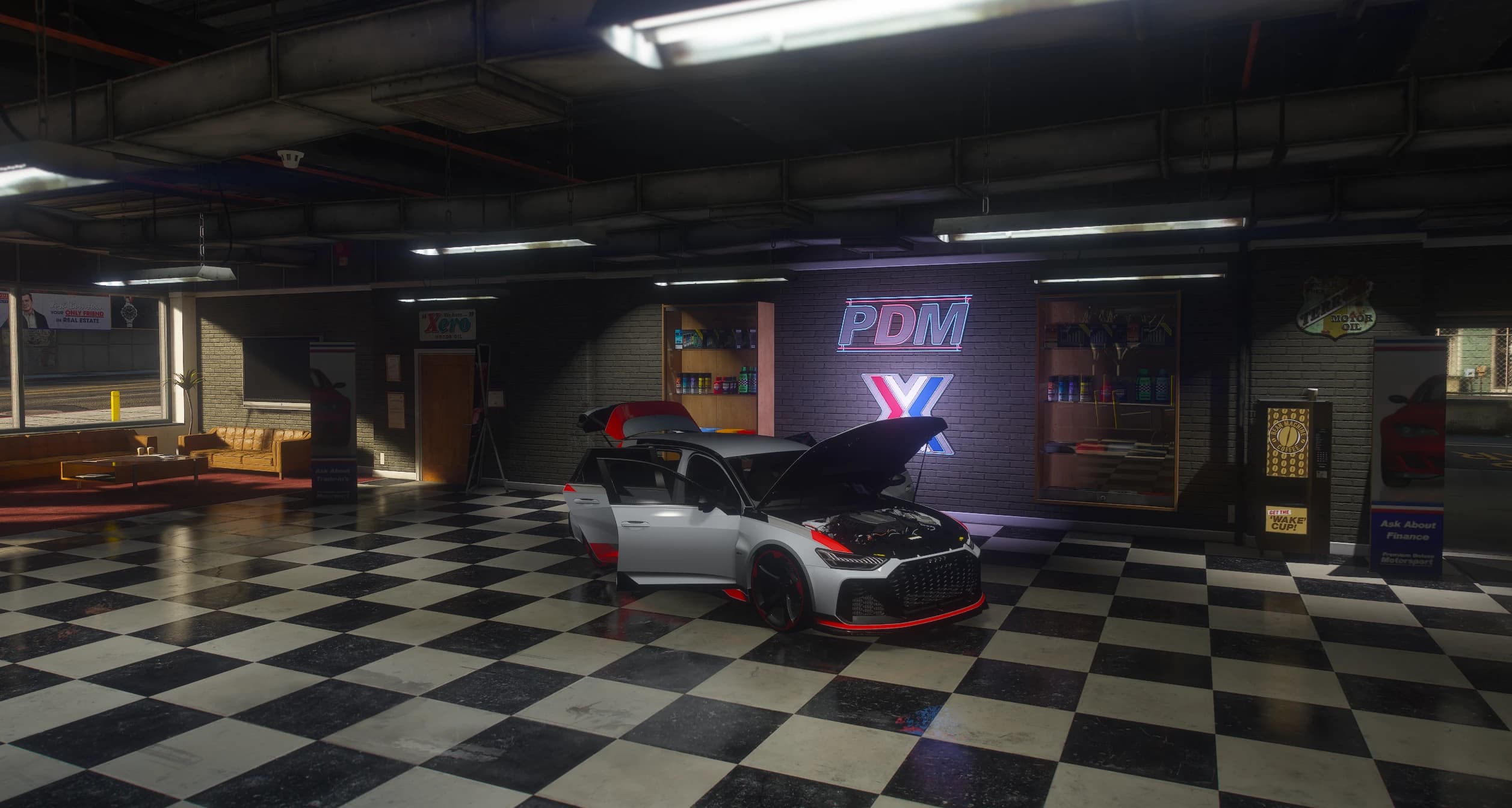 Wide view of the Premium Deluxe Motorsport showroom with the RS6 GT parked under the neon PDM sign, hood, tailgate and driver's door open and the engine bay on show