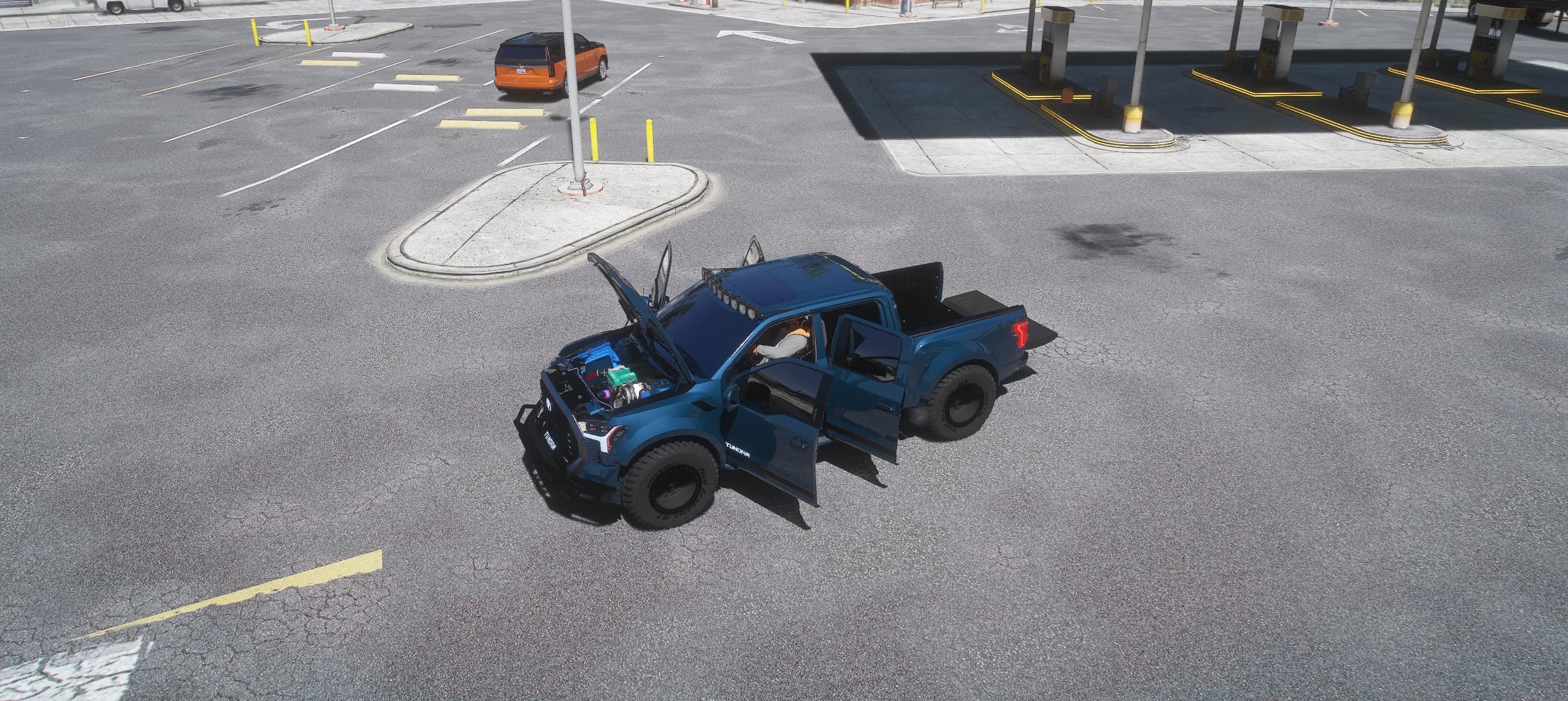 Overhead view of the Tundra on a petrol station forecourt with the bonnet and both doors open, the engine bay visible and the driver sitting inside