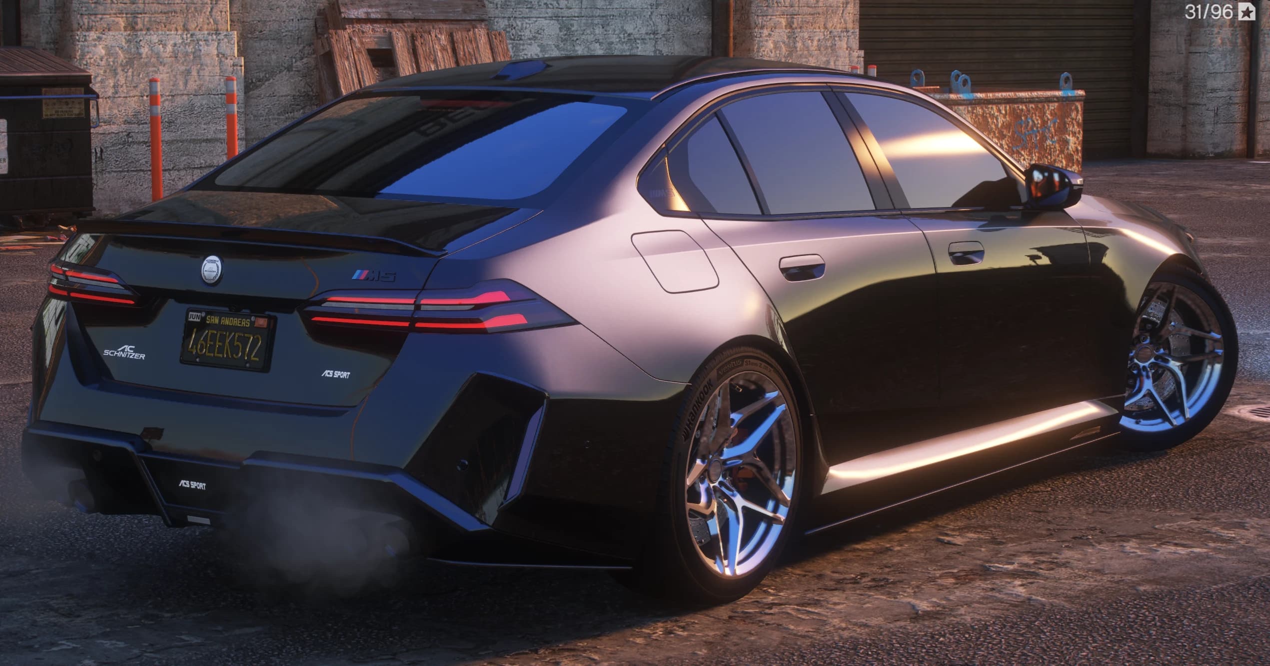 Rear three quarter view showing the ducktail spoiler, AC Schnitzer and ACS Sport badges, quad exhausts and chrome multi spoke wheels in an alley