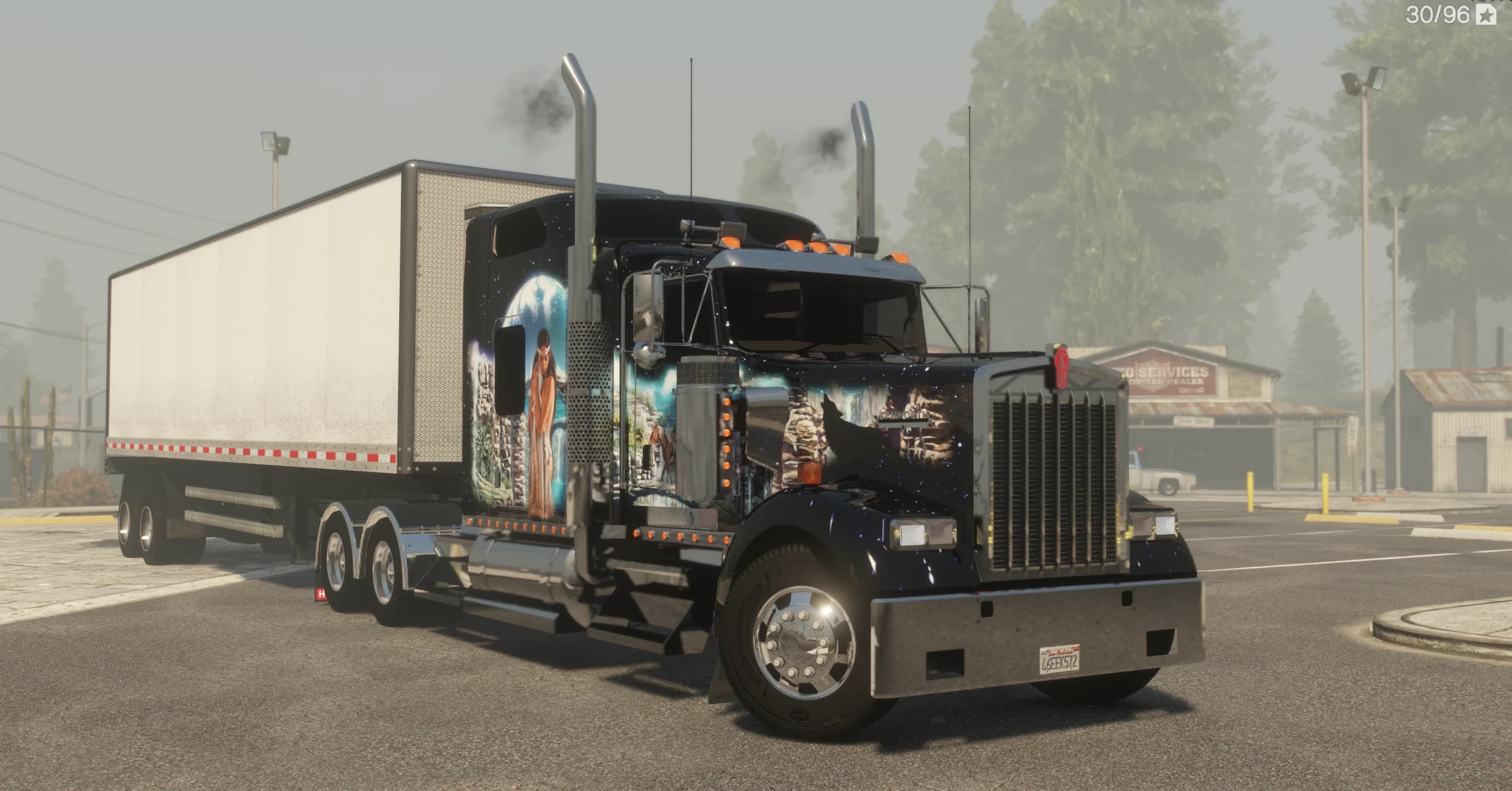The W900 parked with its trailer, showing the howling wolf airbrushed over the hood and a Native American woman painted on the sleeper cab