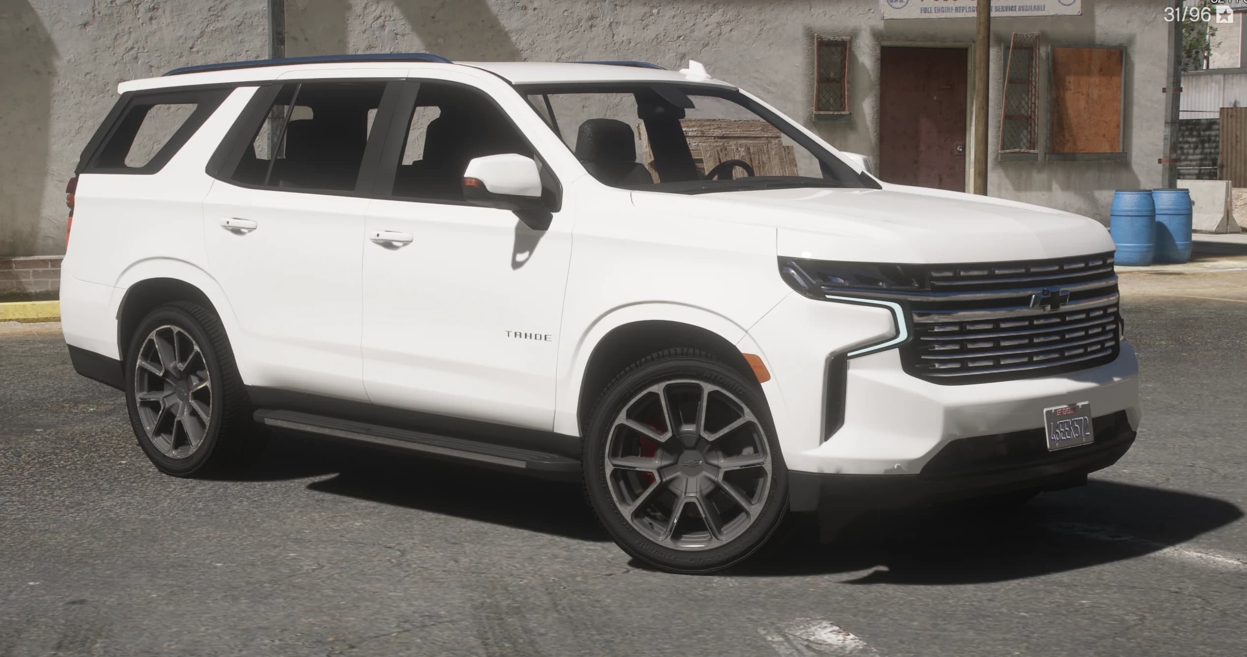 Front three quarter view of the white Chevrolet Tahoe RST with the lit daytime running light strips, wide grille and two tone machined wheels over red calipers