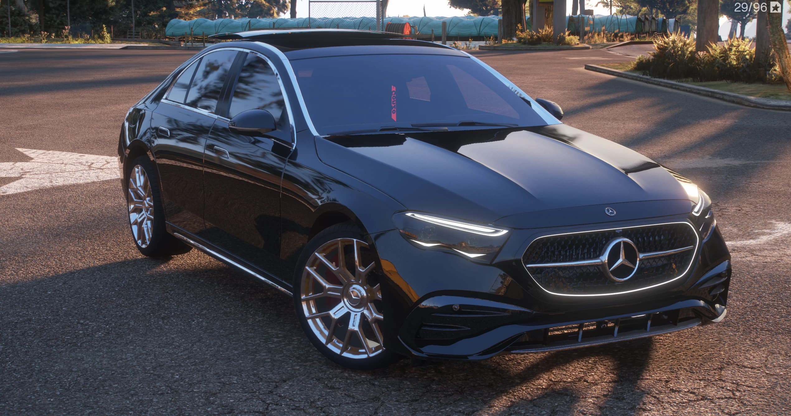 Black 2025 Mercedes-Benz E350 sedan, front three-quarter view with the illuminated star grille and multi-spoke wheels, parked at an intersection