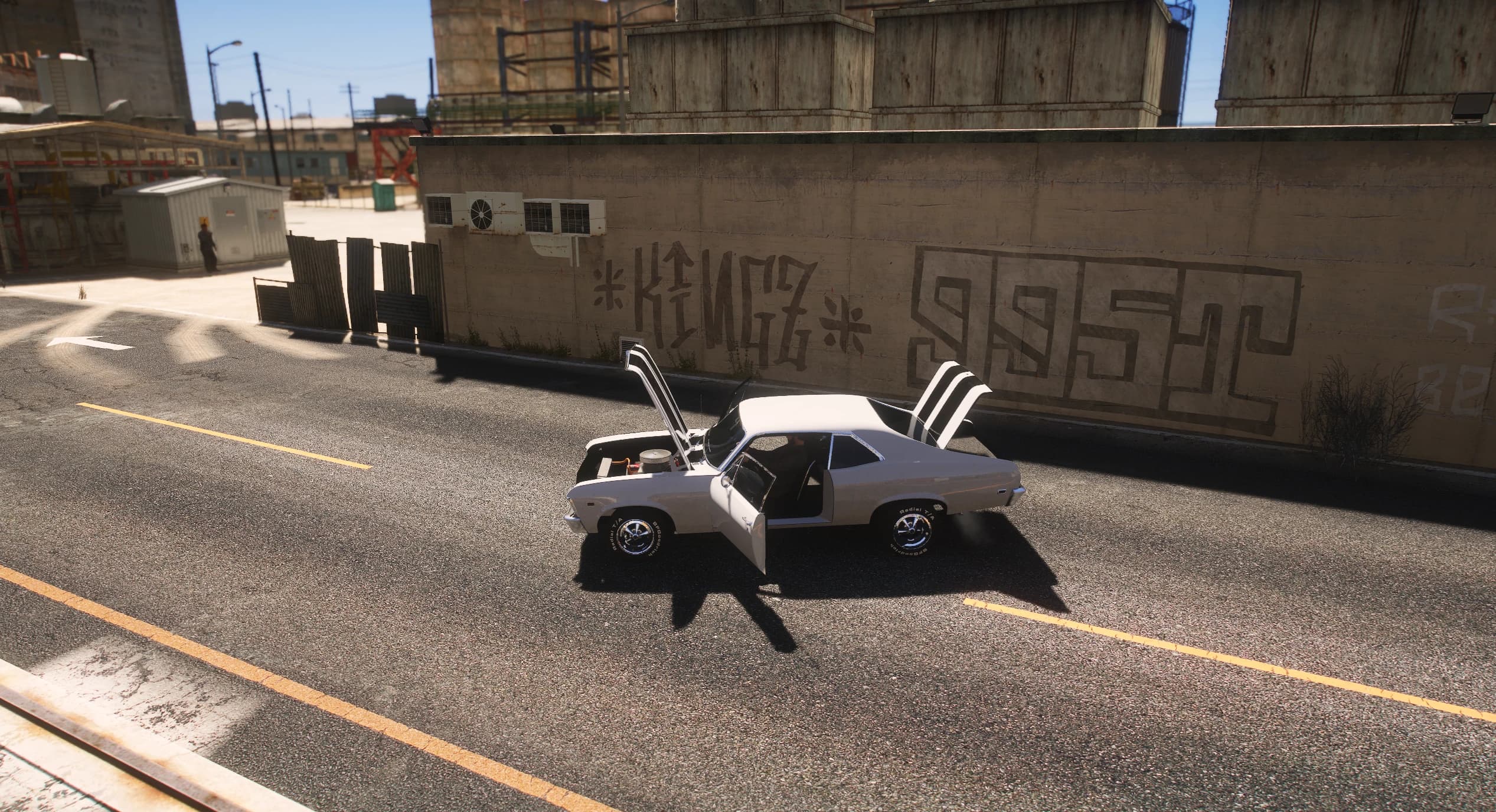 Elevated side view of the white Nova with the hood, the driver's door and the trunk open in front of a graffiti-covered concrete wall, the modelled engine bay visible under the raised hood