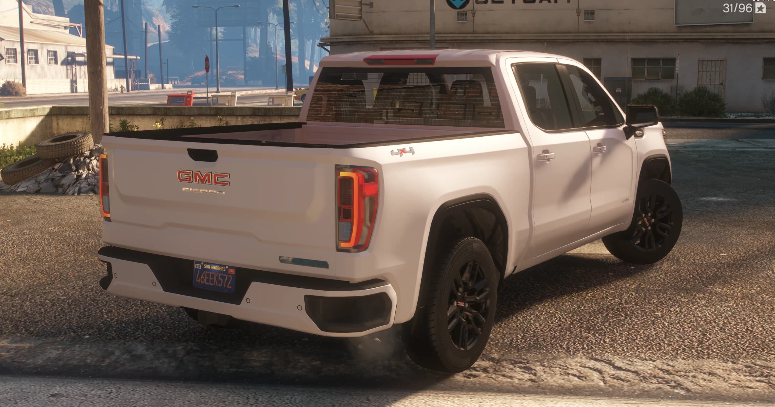 Rear three quarter view showing the GMC and Sierra lettering on the tailgate, C shaped taillights and the 4x4 badge on the bed
