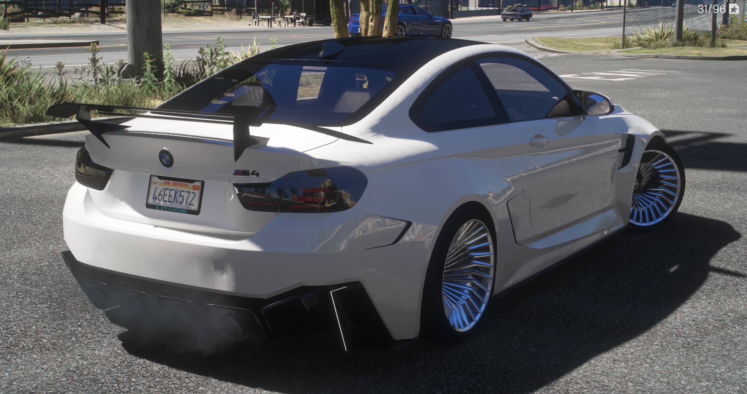 Rear three quarter view with the tall swan neck rear wing, four exhaust tips in the diffuser, the M4 badge and a D.ICY Customs plate frame