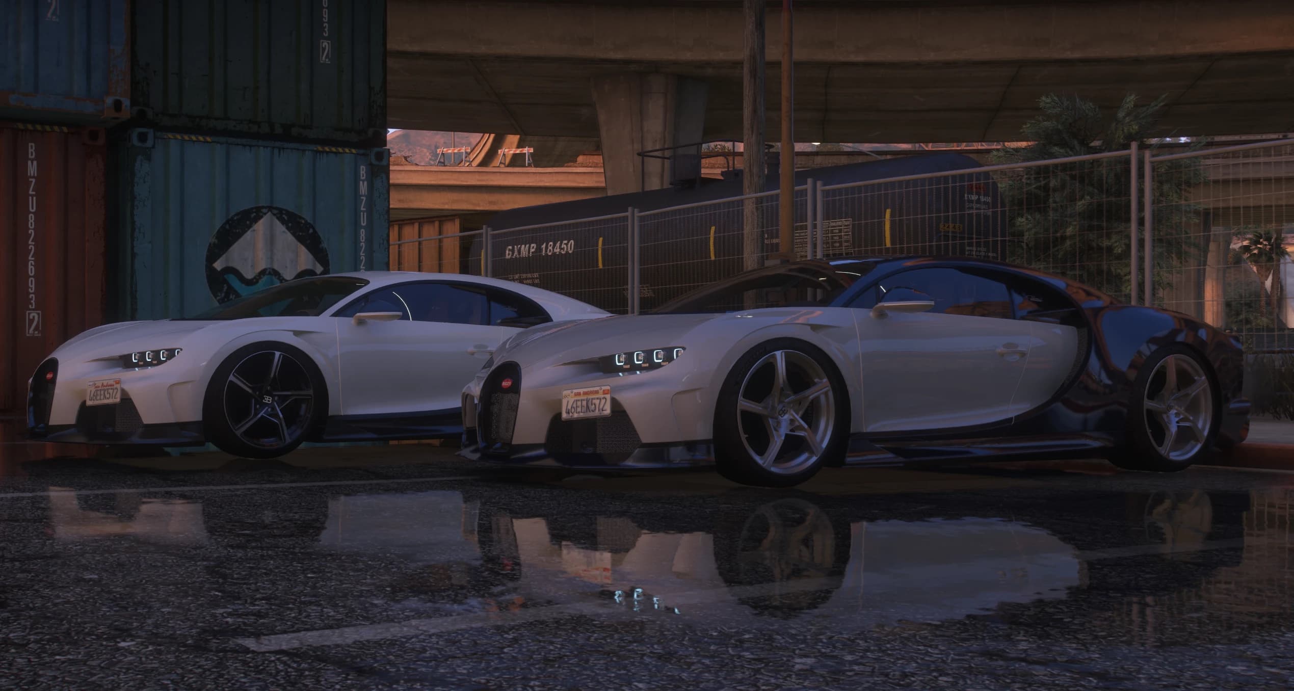 The two add-on cars parked side by side at dusk, one in cream and one in white over blue carbon