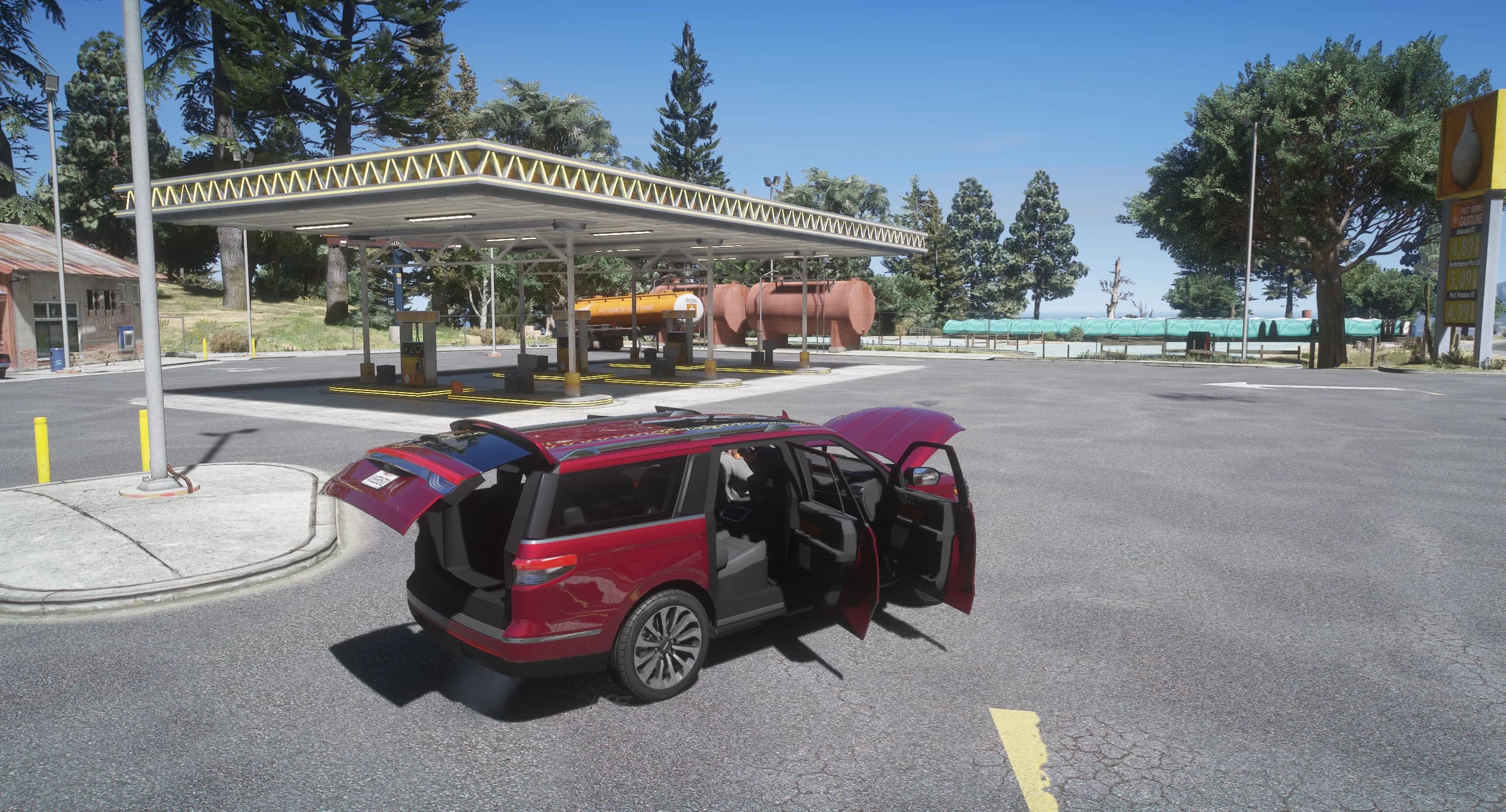 The red Navigator parked in front of a rural petrol station canopy with the tailgate, both right-hand doors and the bonnet open, showing the seats inside