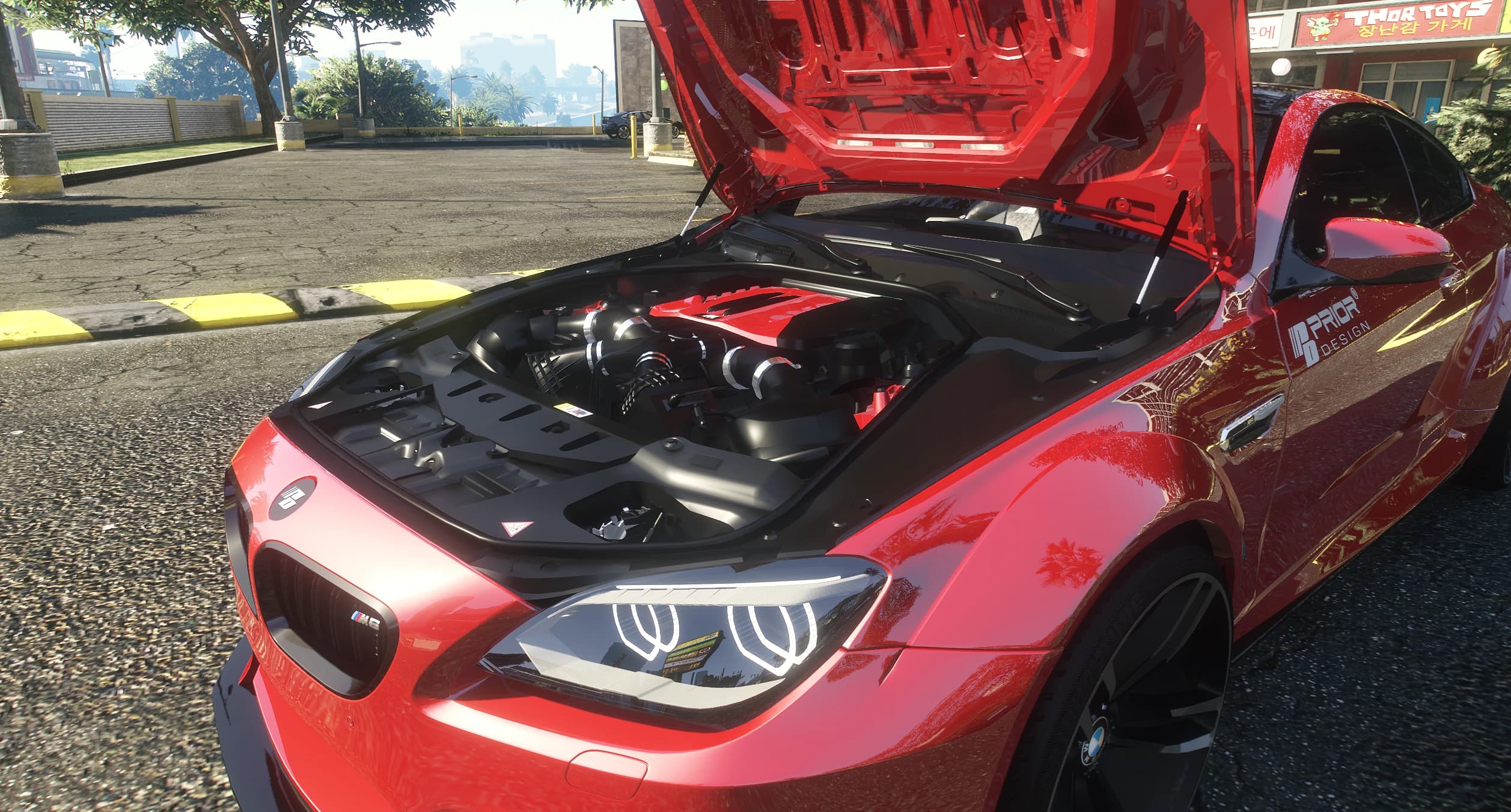 Open hood of the M6 showing the modeled twin turbo V8 engine bay with the red cover