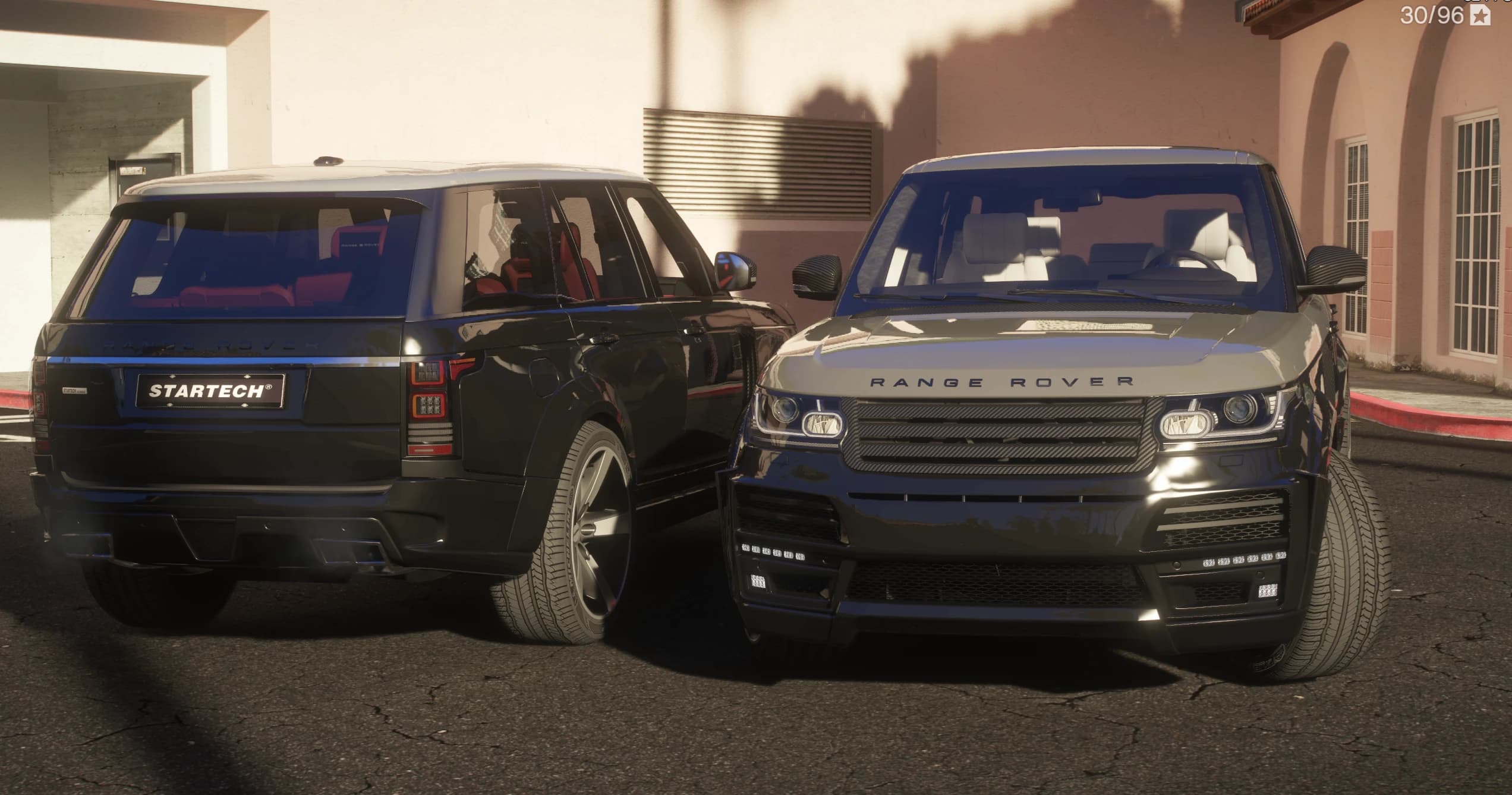 Rear of the black Startech Range Rover with the STARTECH tailgate plate next to the front of the grey unit with its carbon look grille